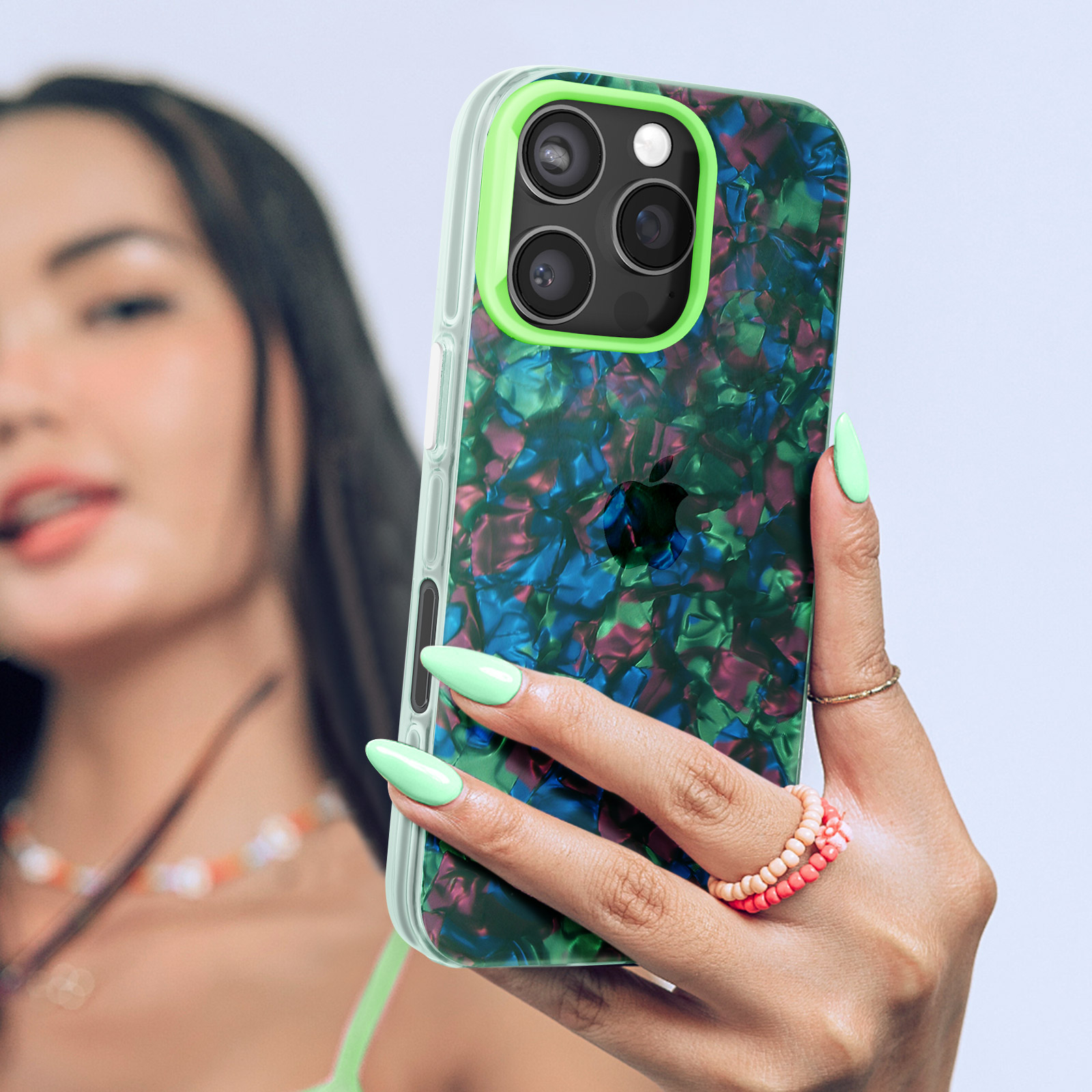 Donna che tiene un telefono con una custodia. La custodia ha un motivo astratto colorato.