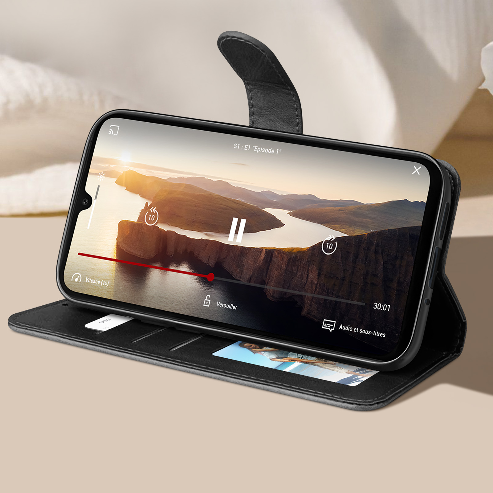 Telefono in una custodia a libro nera, che riproduce un video.
