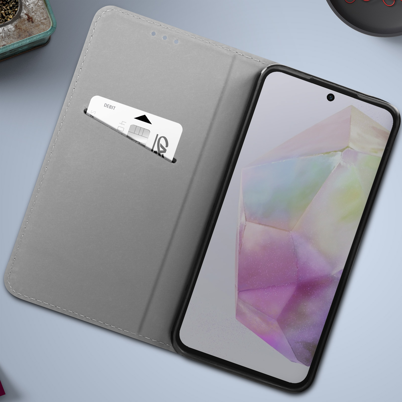Custodia per telefono aperta, con una carta nella fessura. Lo schermo mostra un design astratto colorato.
