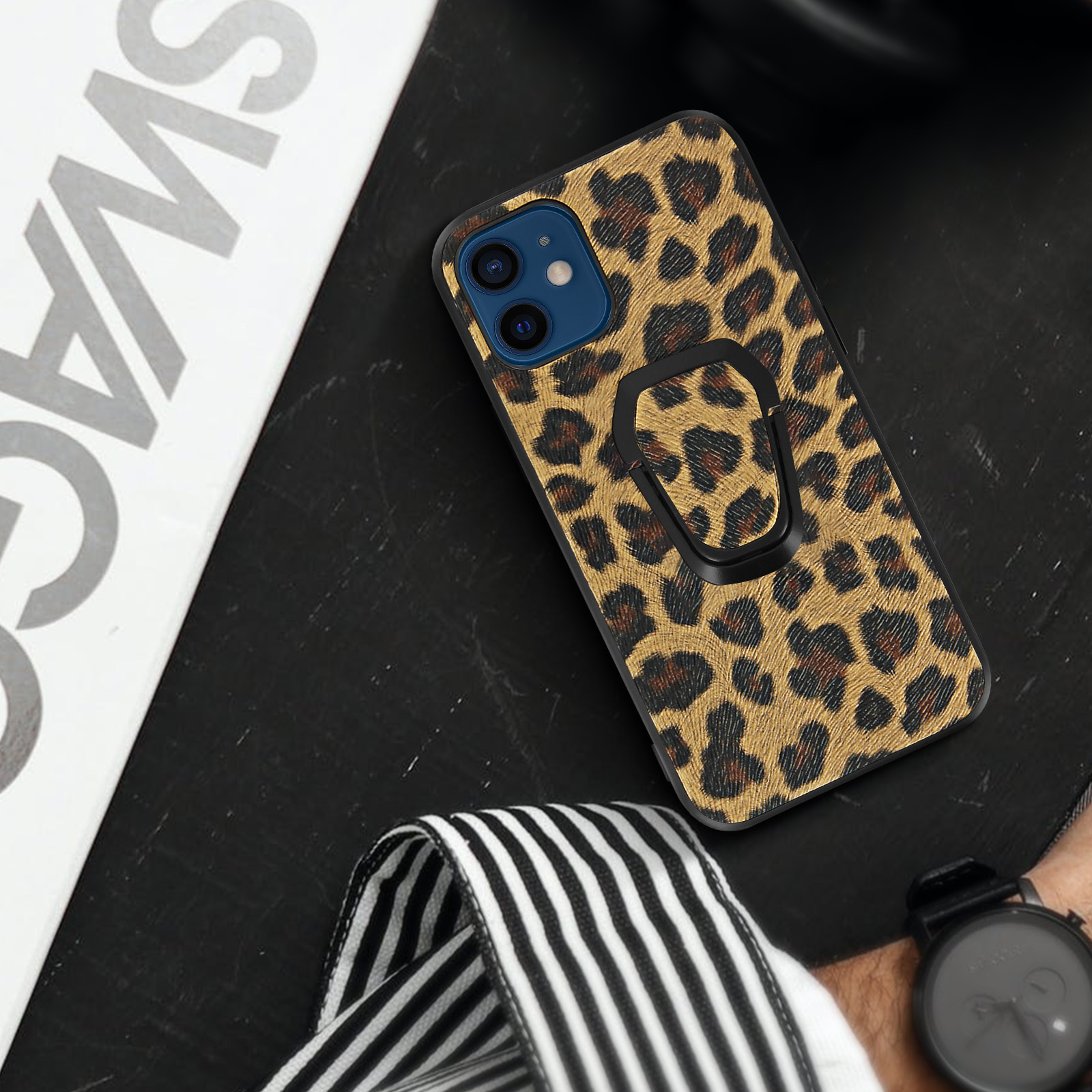 Custodia per telefono con motivo leopardato e anello di supporto, su una superficie scura.