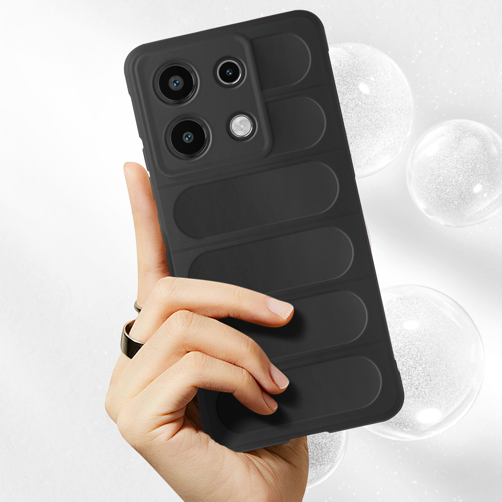 Una custodia nera per telefono è tenuta da una mano, con bolle sullo sfondo.