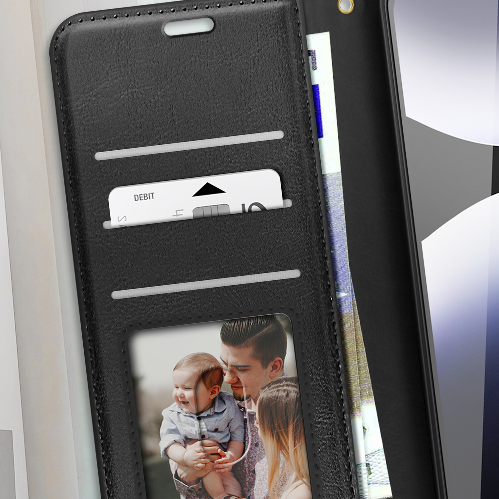 Custodia nera per telefono con fessure per carte, foto di famiglia e carta di debito. Sfondo è un muro.