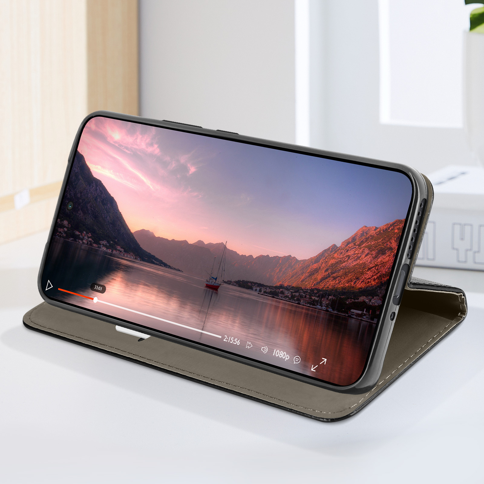 Telefono in una custodia, che mostra un video di un tramonto su un lago.