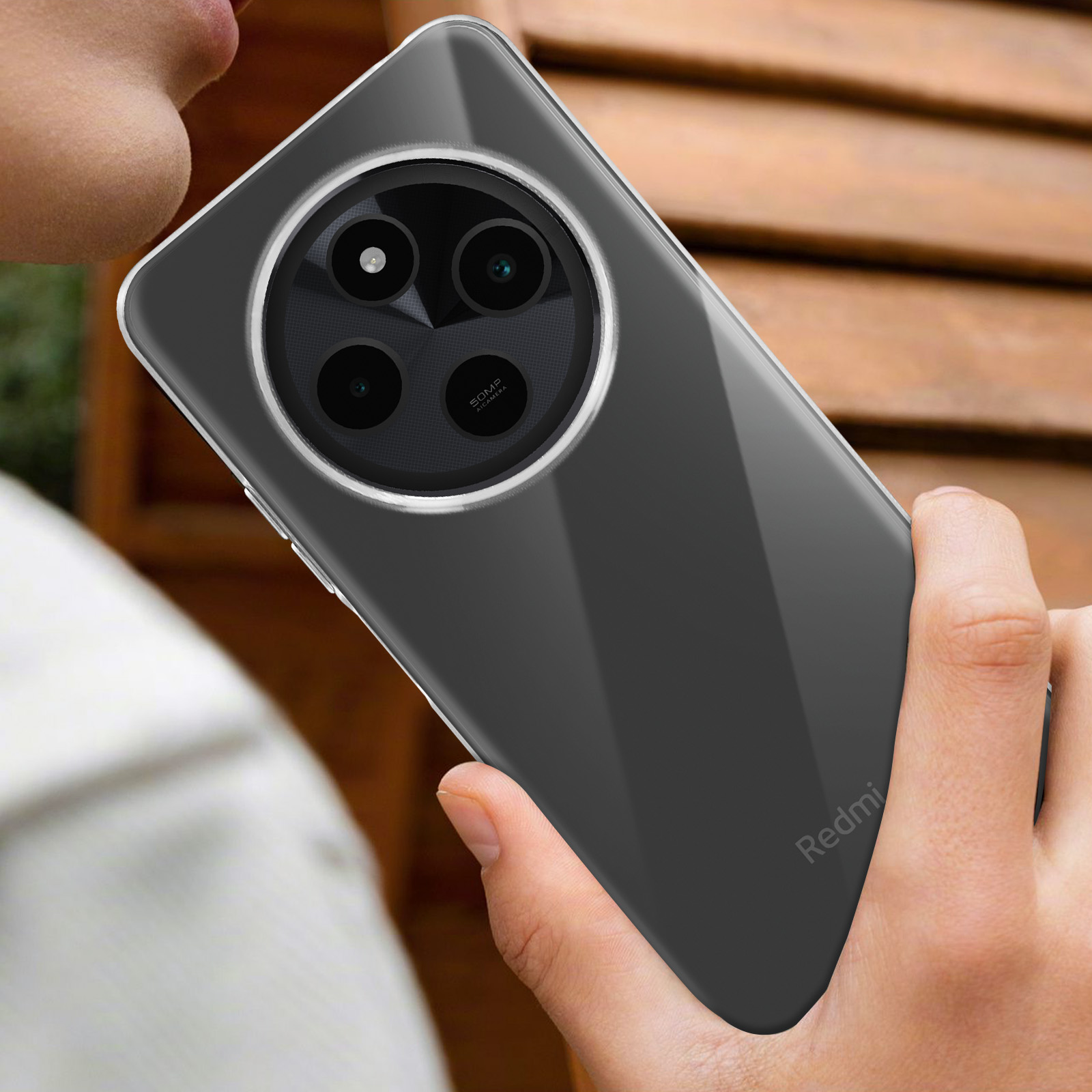 Una persona tiene in mano un telefono con una custodia trasparente. Il telefono ha obiettivi della fotocamera.
