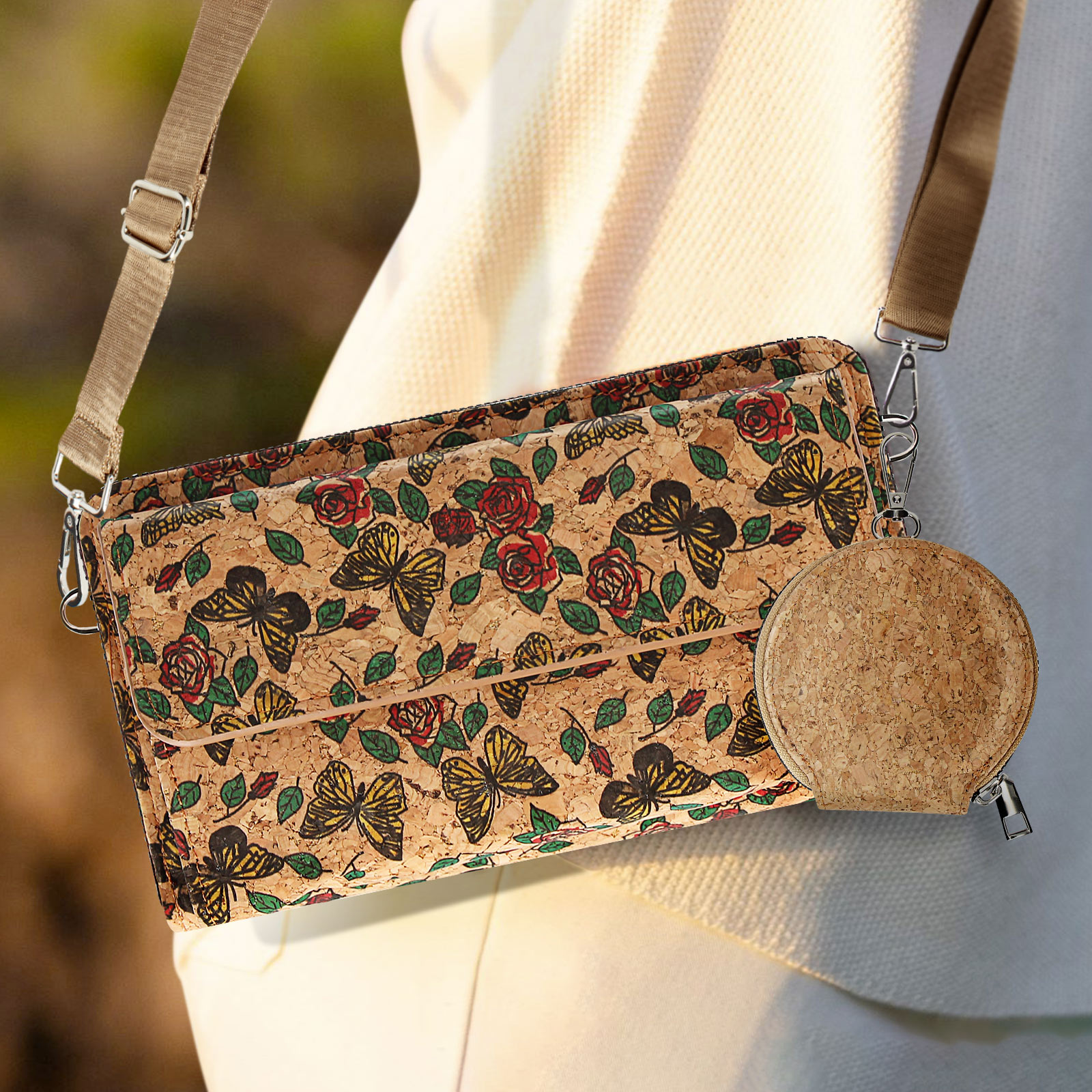 Eine Umhängetasche und eine runde Korkbrieftasche mit Schmetterlings- und Rosenmuster.