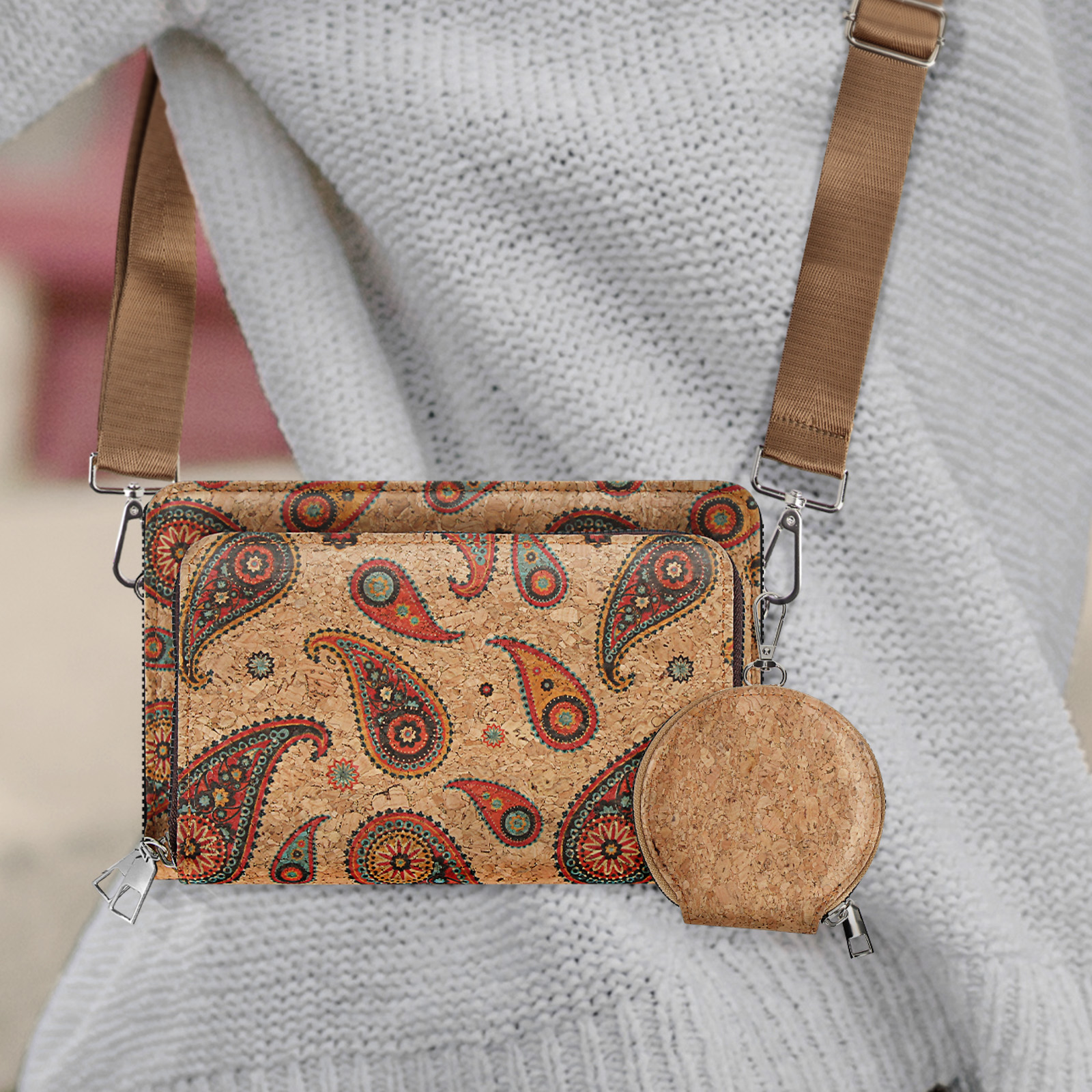 Umhängetasche mit Paisley-Print und passendem runden Portemonnaie, beigefarbener Riemen, Person trägt einen Pullover.