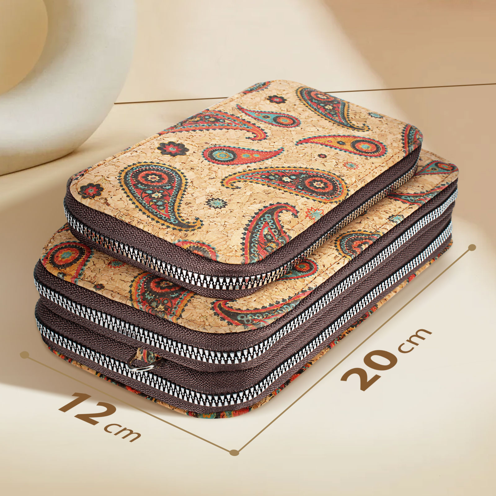 Zwei gestapelte, korkähnliche Geldbörsen. Paisley-Muster mit braunen Reißverschlüssen. Maße sind 12 cm x 20 cm.