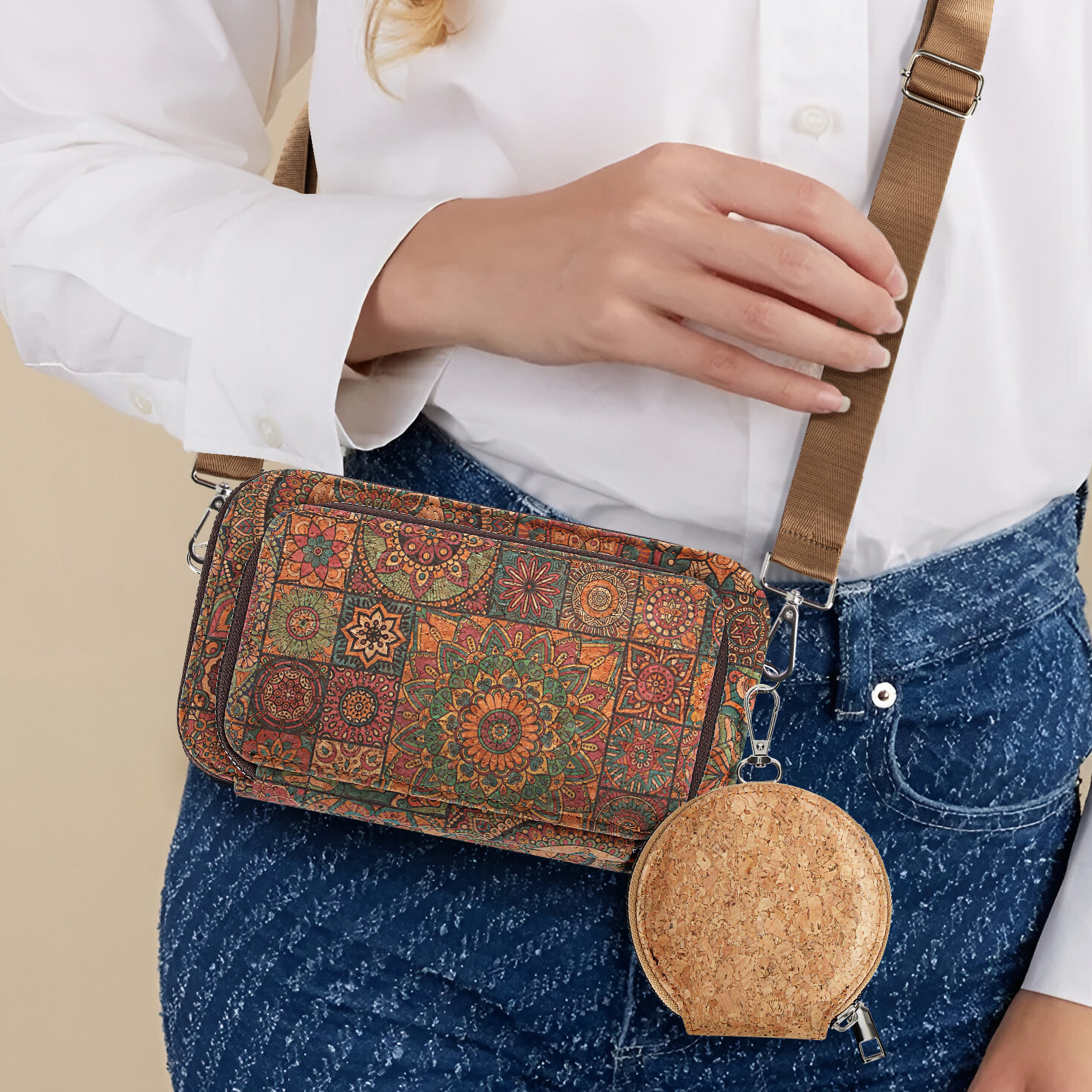 Eine Frau hält eine gemusterte Tasche mit Umhängeriemen und eine kleine Geldbörse.
