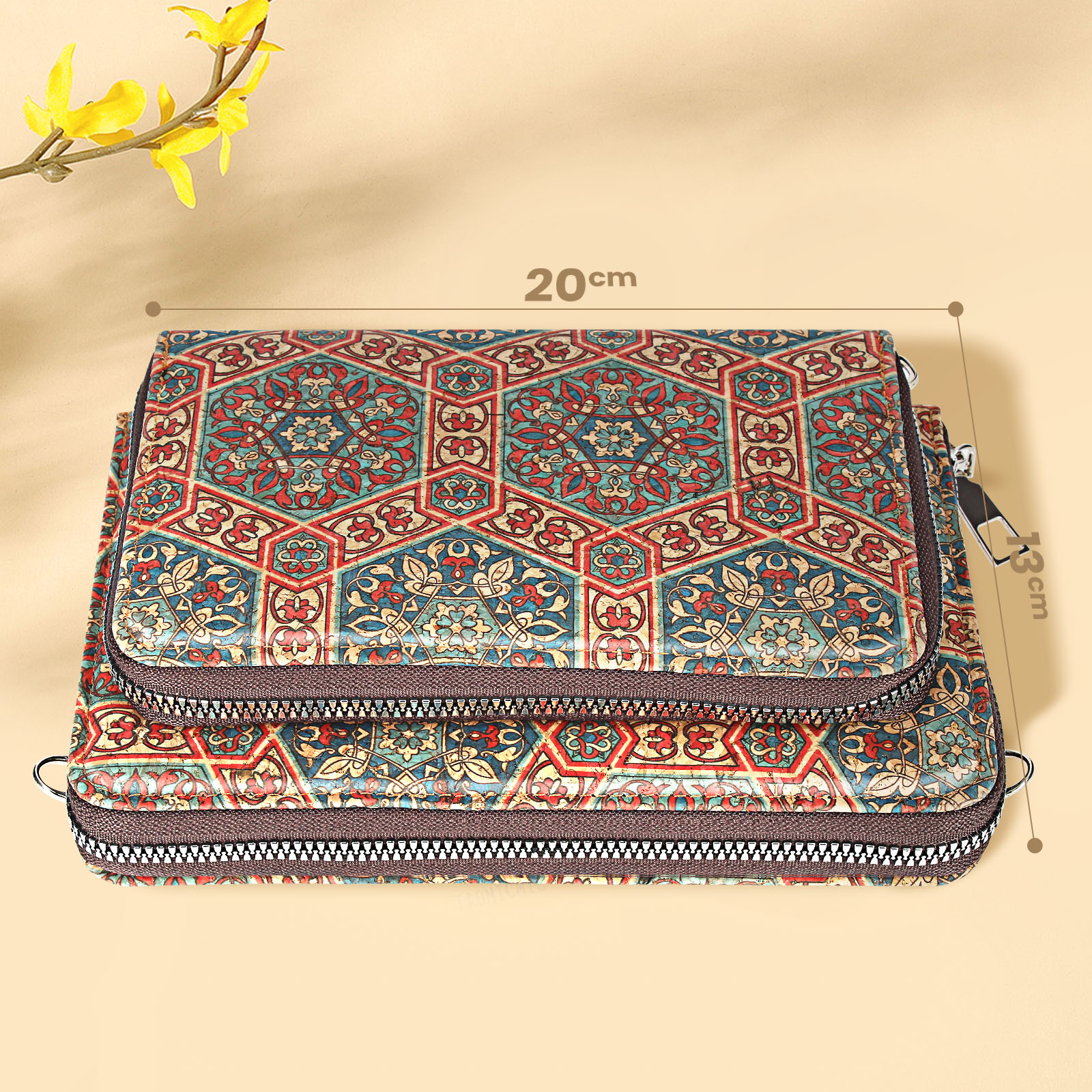 Kork-Geldbörse mit farbenfrohem geometrischem Design, 20 cm x 13 cm. Eine gelbe Blume im Hintergrund.
