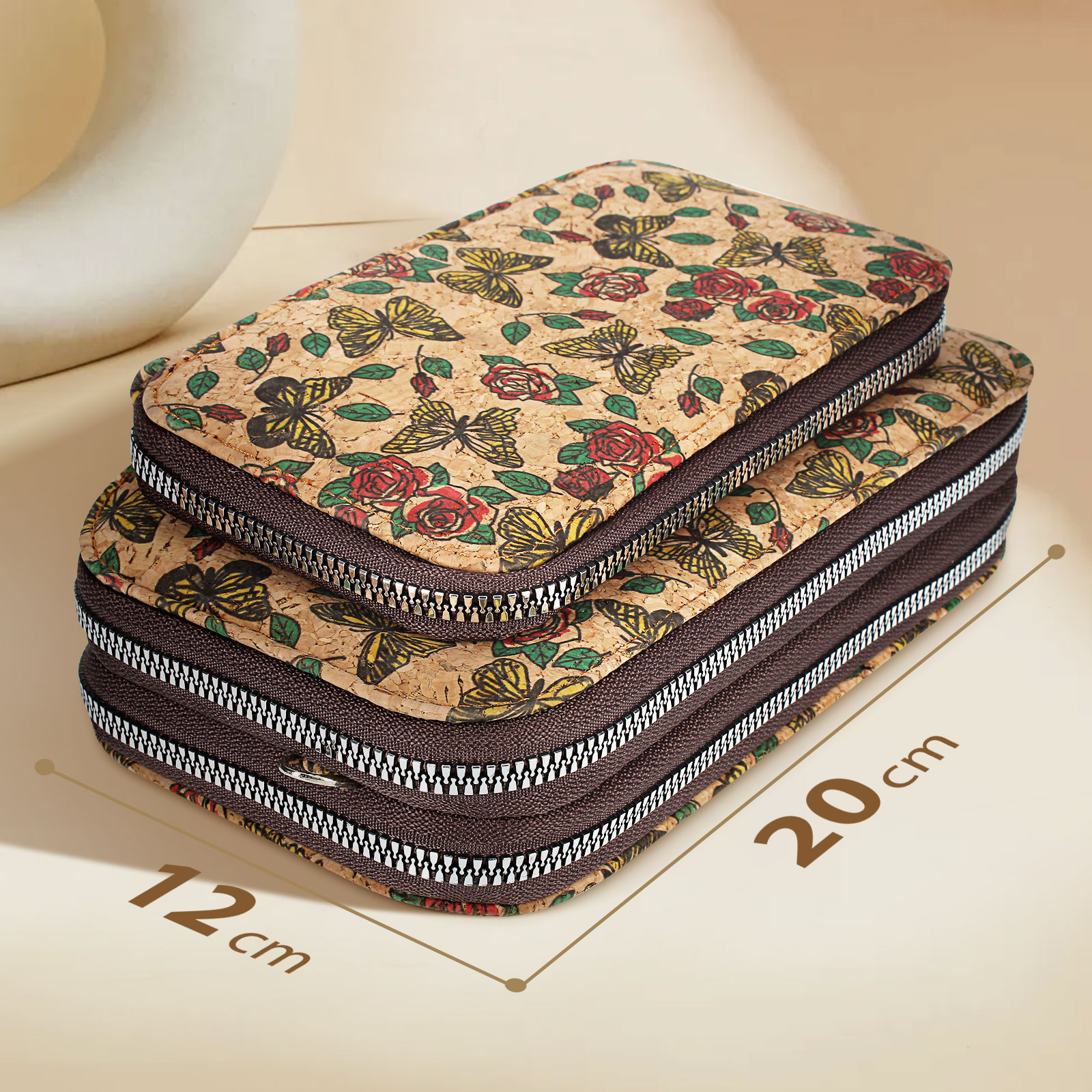 Zwei Korkbrieftaschen mit Schmetterlings- und Rosenmustern. Reißverschlüsse sichtbar. Eine ist 12 cm, die andere 20 cm groß.