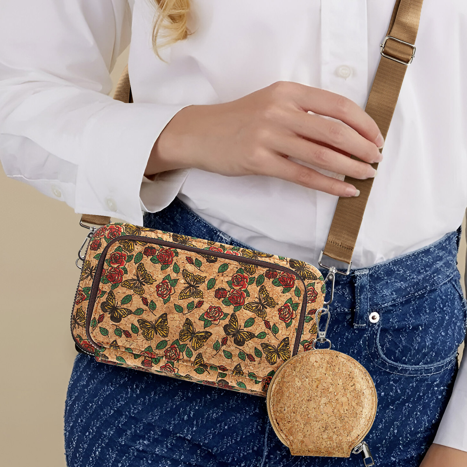 Eine Frau mit weißem Hemd und Jeans, hält eine Handtasche mit floralem Design.