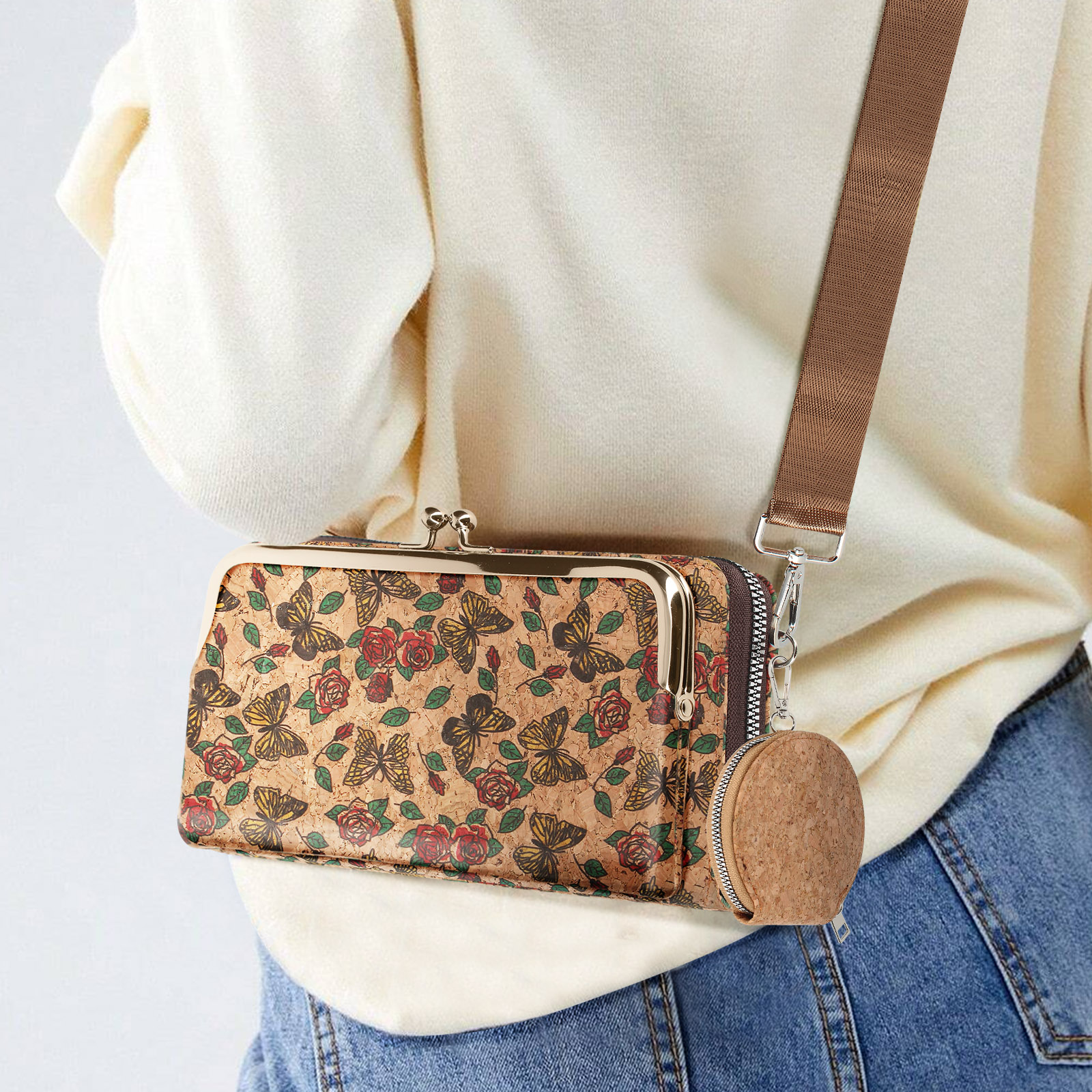 Frau trägt Kork-Clutch mit Mandala-Muster, braunem Gurt und runder Geldbörse. Jeans und weißes Hemd.