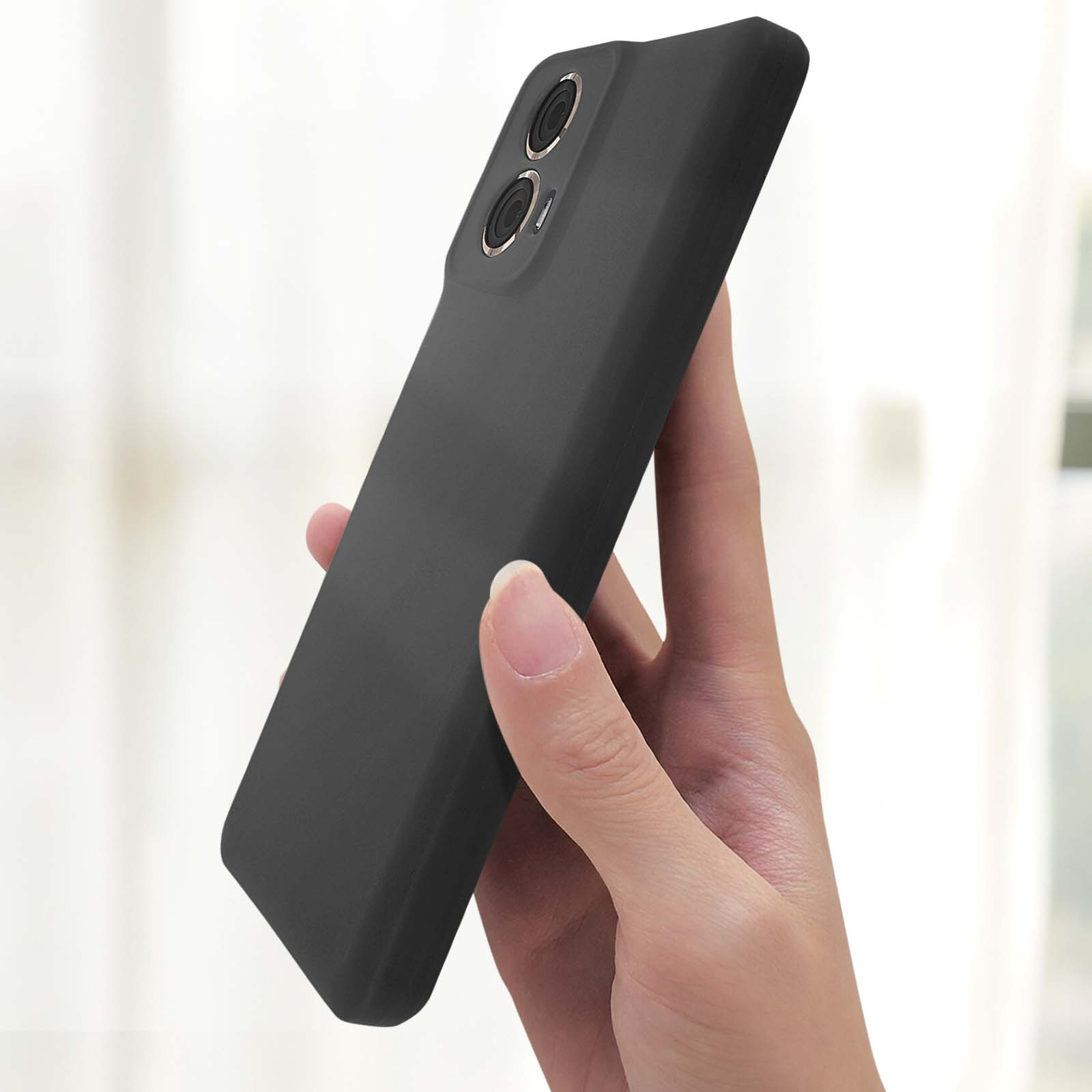 Una mano tiene una custodia nera con fori per la fotocamera. La custodia è opaca e liscia.