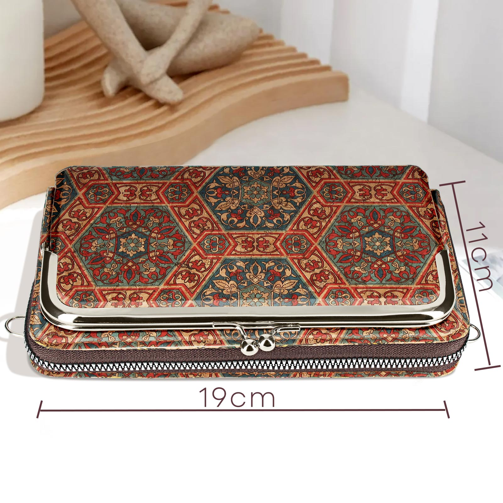 Clutch-Tasche auf weißer Oberfläche. Die Tasche hat ein farbenfrohes Muster.