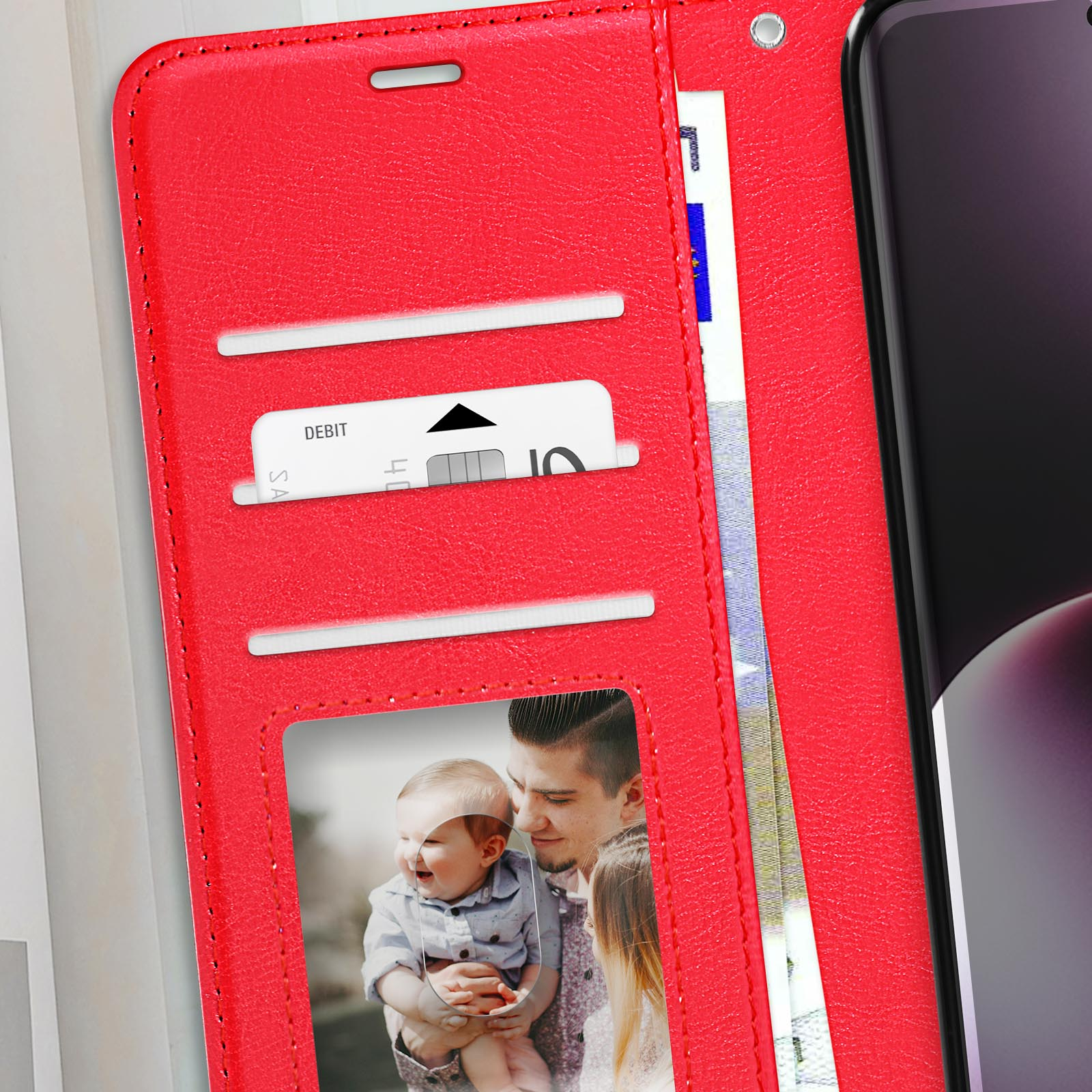 Custodia rossa aperta con carte, denaro e foto di famiglia. Telefono non in vista.