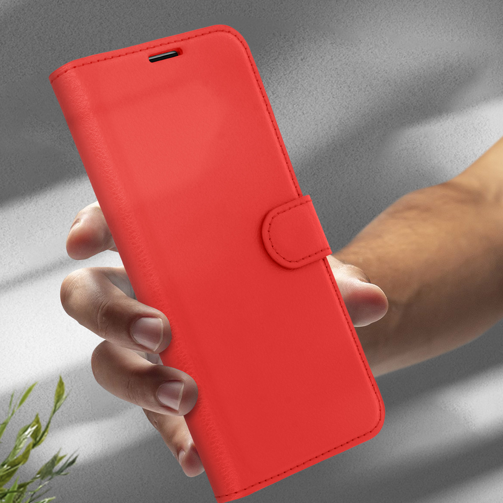 Mano che tiene un portafoglio rosso. Il portafoglio è chiuso.