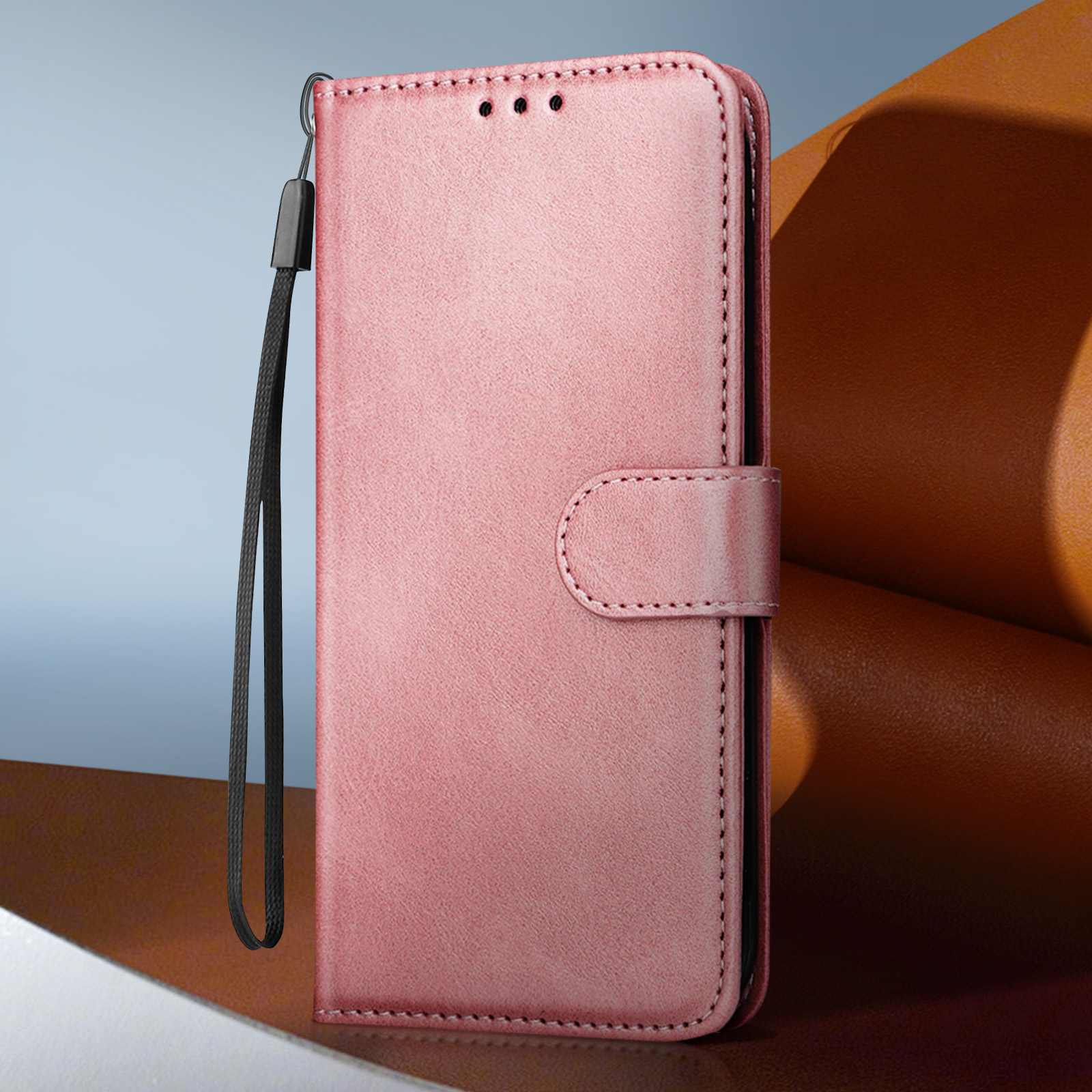Custodia per telefono rosa, chiusa, con cinturino da polso. Dispone di quattro punti sulla parte anteriore.