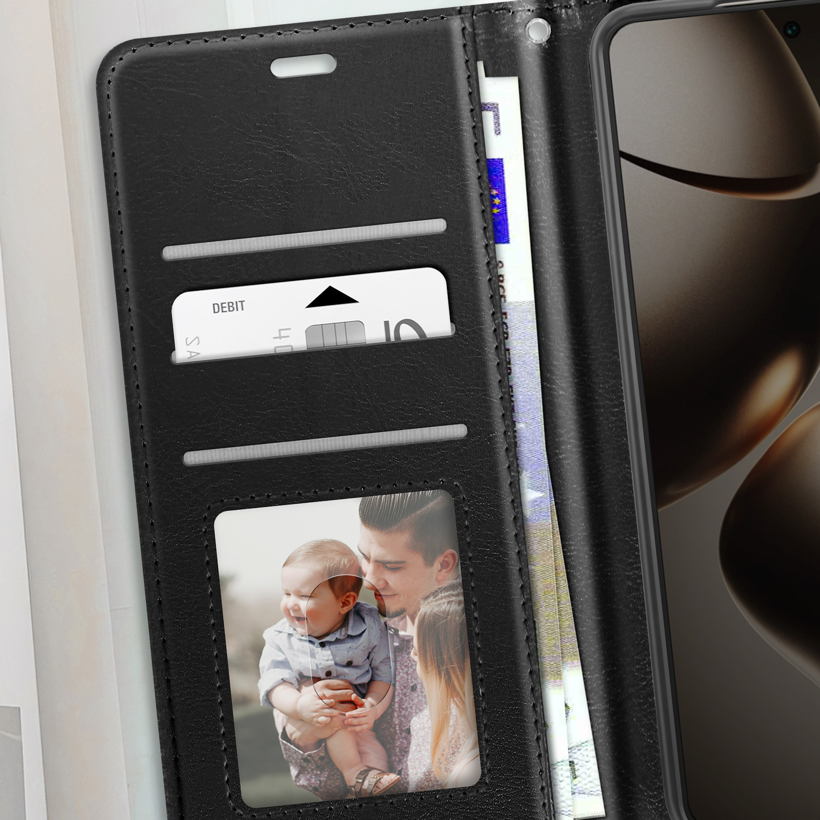 Custodia per telefono nera aperta. All'interno: soldi, carta di credito e foto di famiglia.