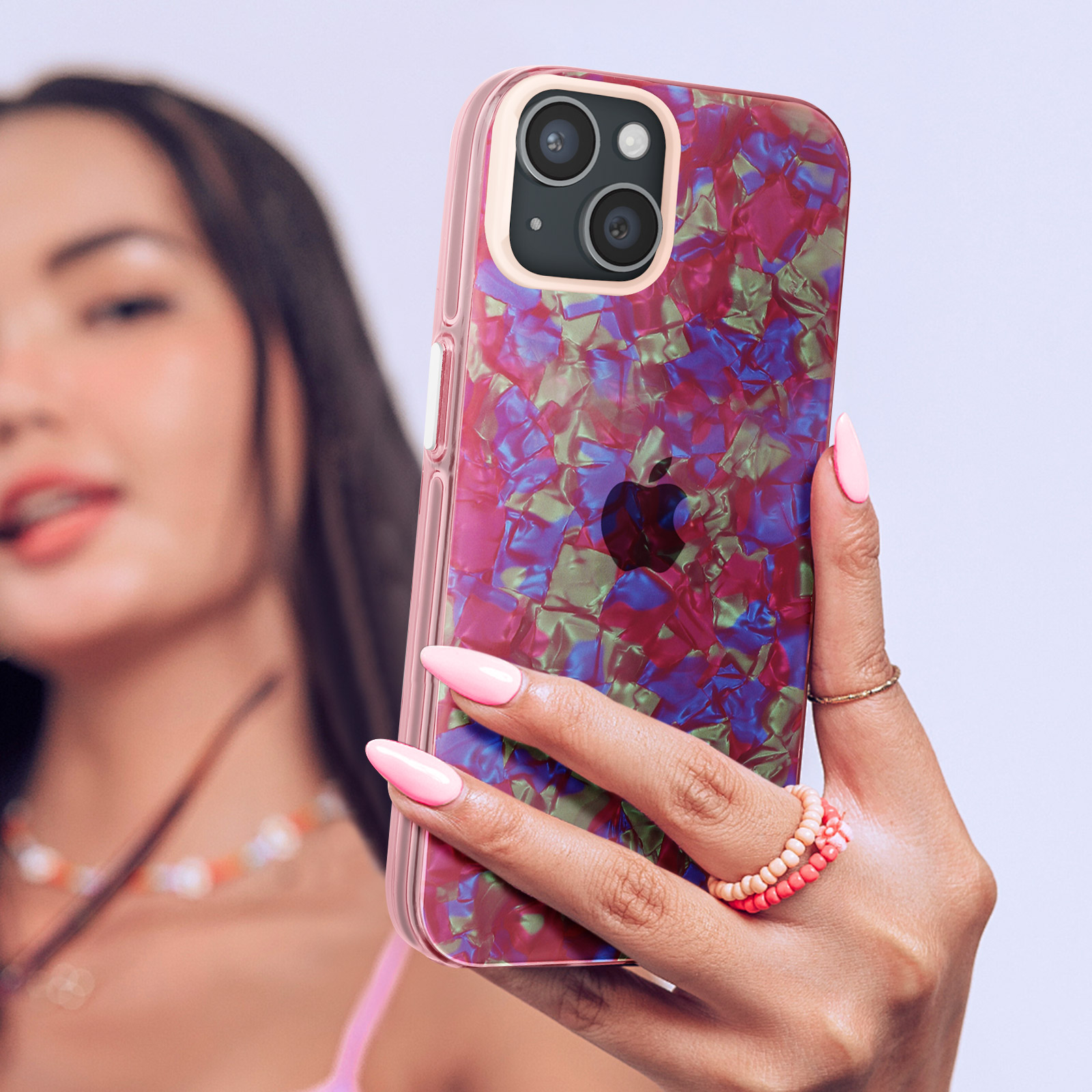 Donna con telefono con custodia rosa iridescente, scatta una foto.