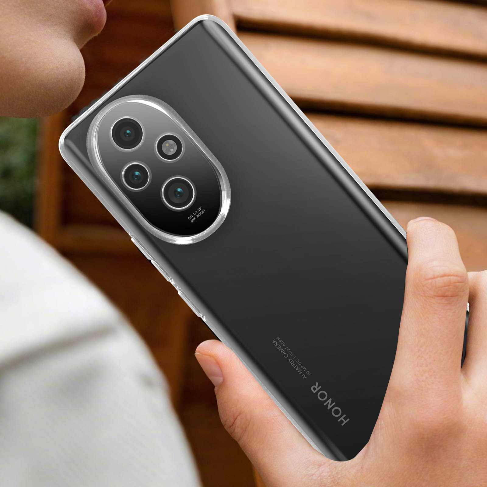 Mano che tiene un telefono nero con un rigonfiamento della fotocamera. Il telefono ha una custodia trasparente.
