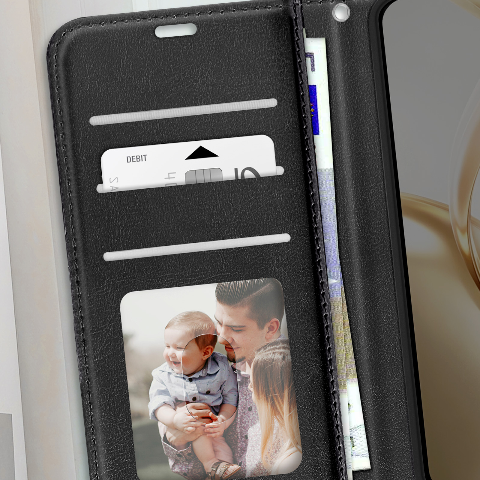 Custodia nera per telefono, aperta, con carte, denaro e foto di famiglia.