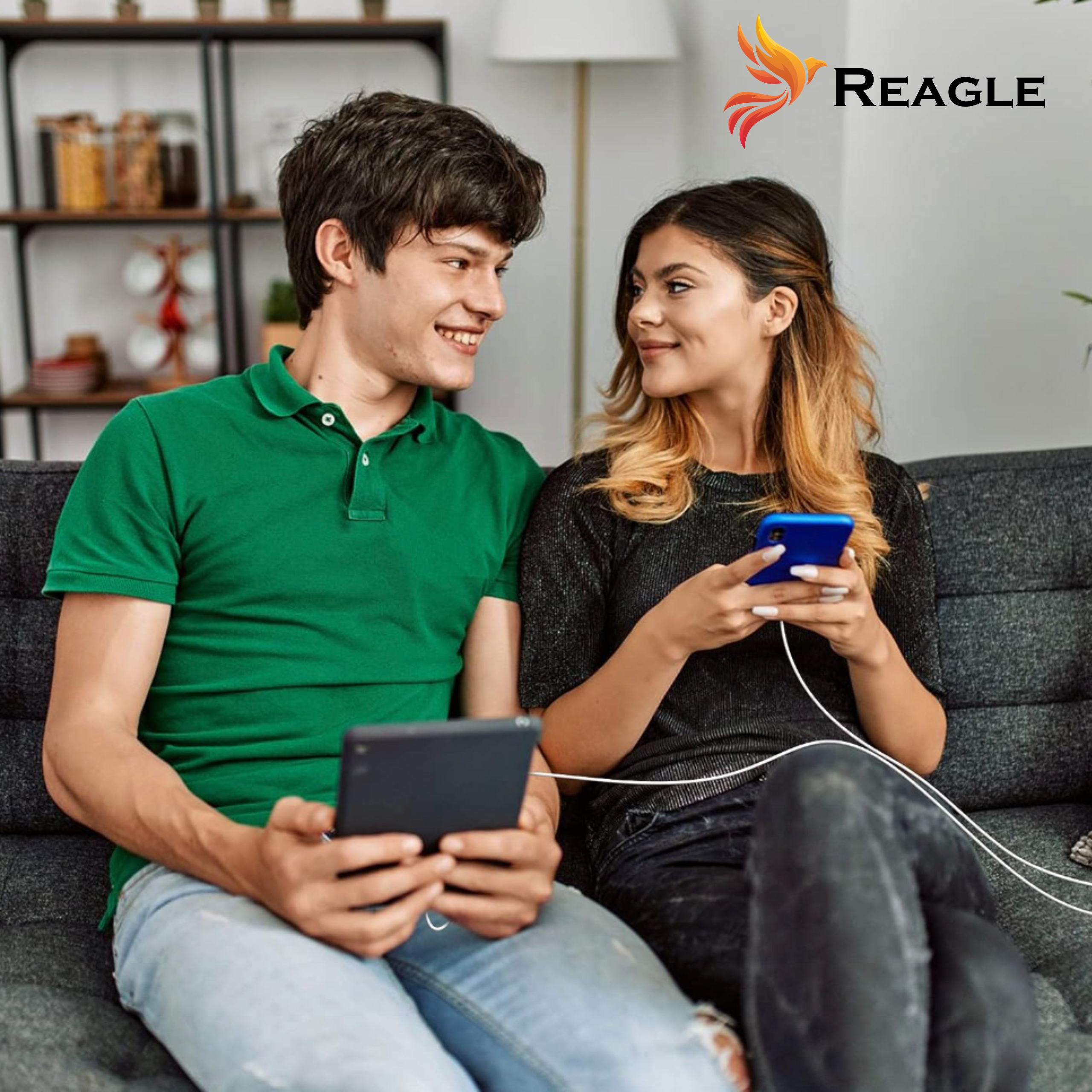 Para siedząca na kanapie, patrząca na siebie podczas korzystania z telefonów.