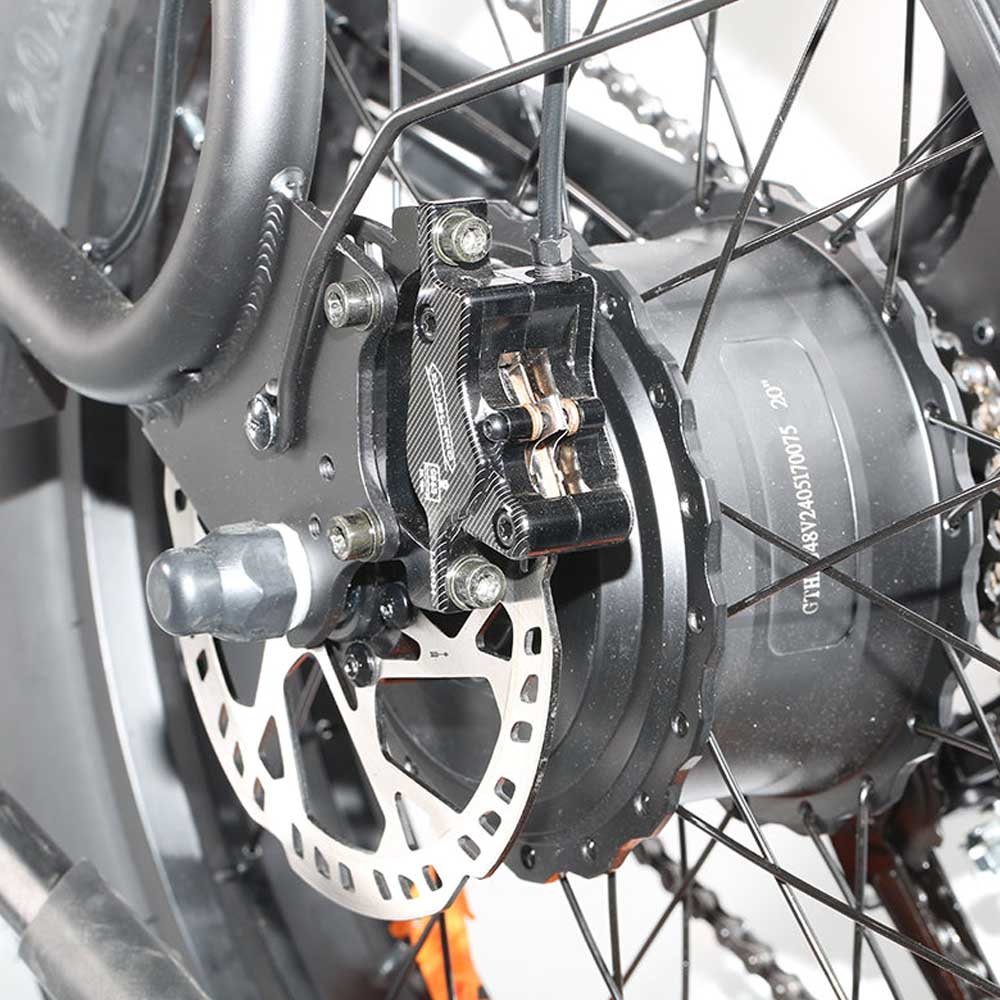 Primer plano de la rueda trasera de una e-bike con frenos de disco y rueda negra.