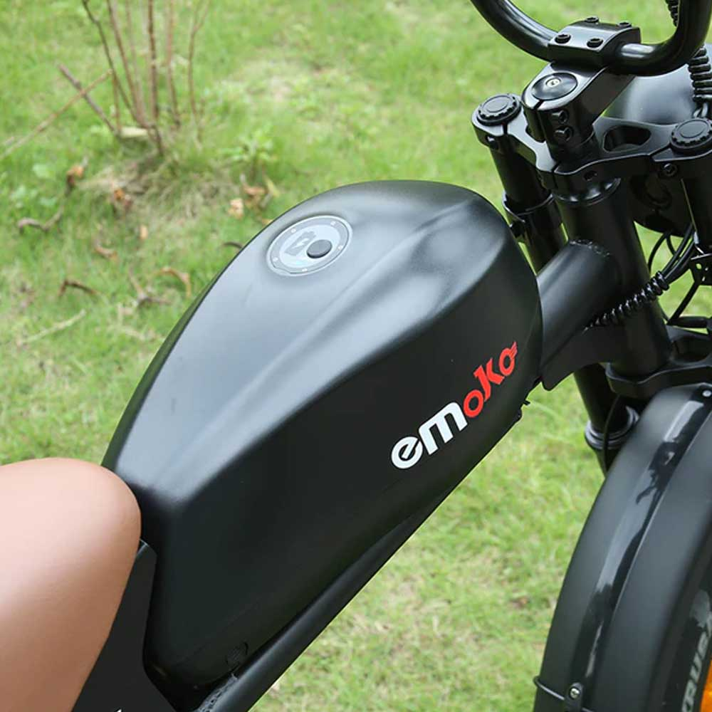 Bicicleta eléctrica negra con batería. La bici tiene la marca 'emoko' en la batería y un cuadro negro.