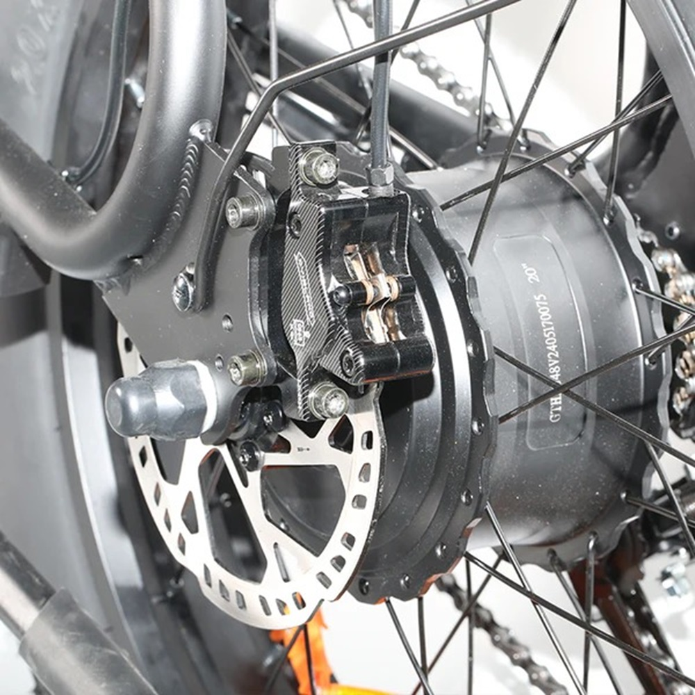 Primer plano del sistema de freno de disco de la rueda trasera de una bicicleta eléctrica, motor visible.