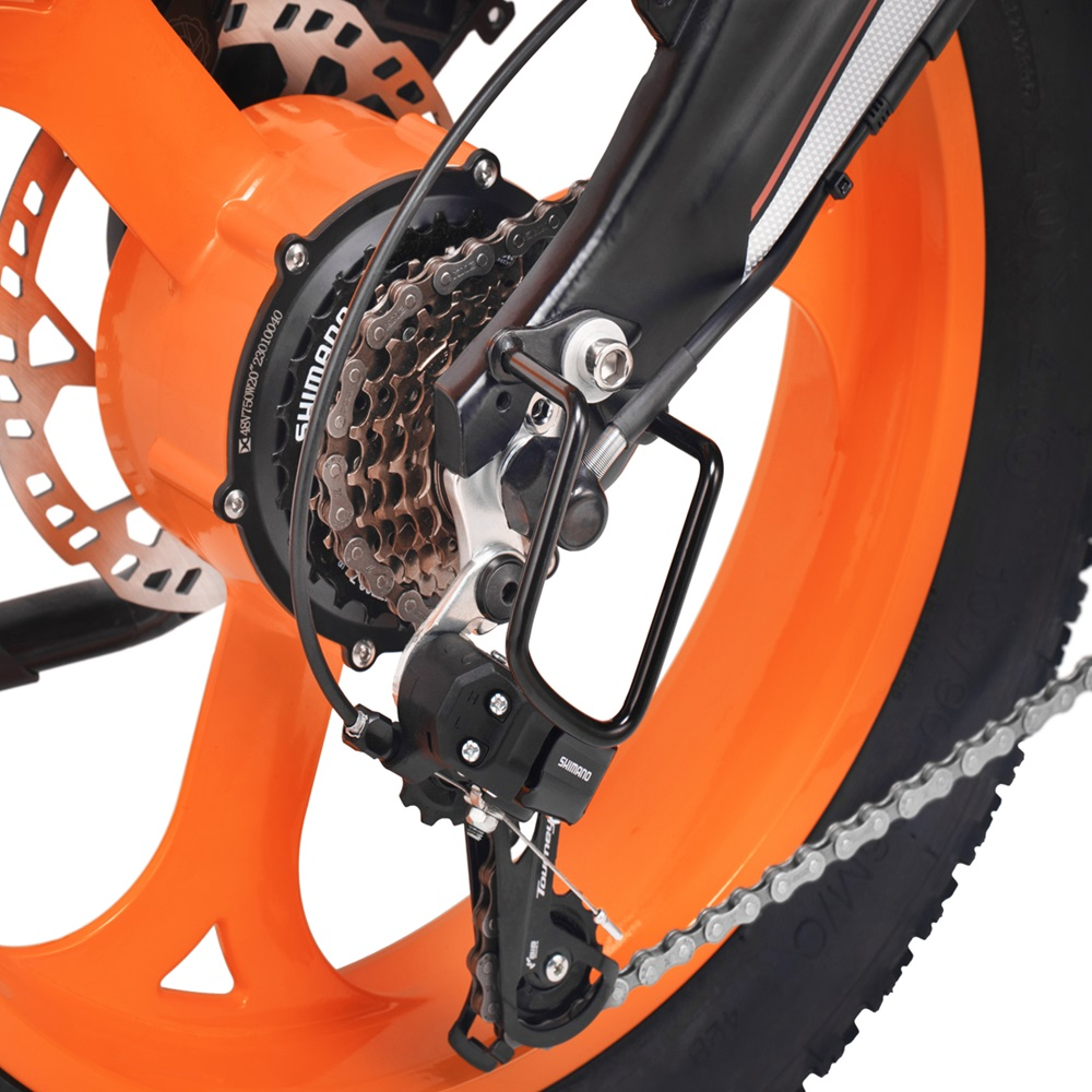 Nahaufnahme der Zahnräder eines orangefarbenen Elektrofahrrads, schwarze und silberne Details, schwarzer Reifen.