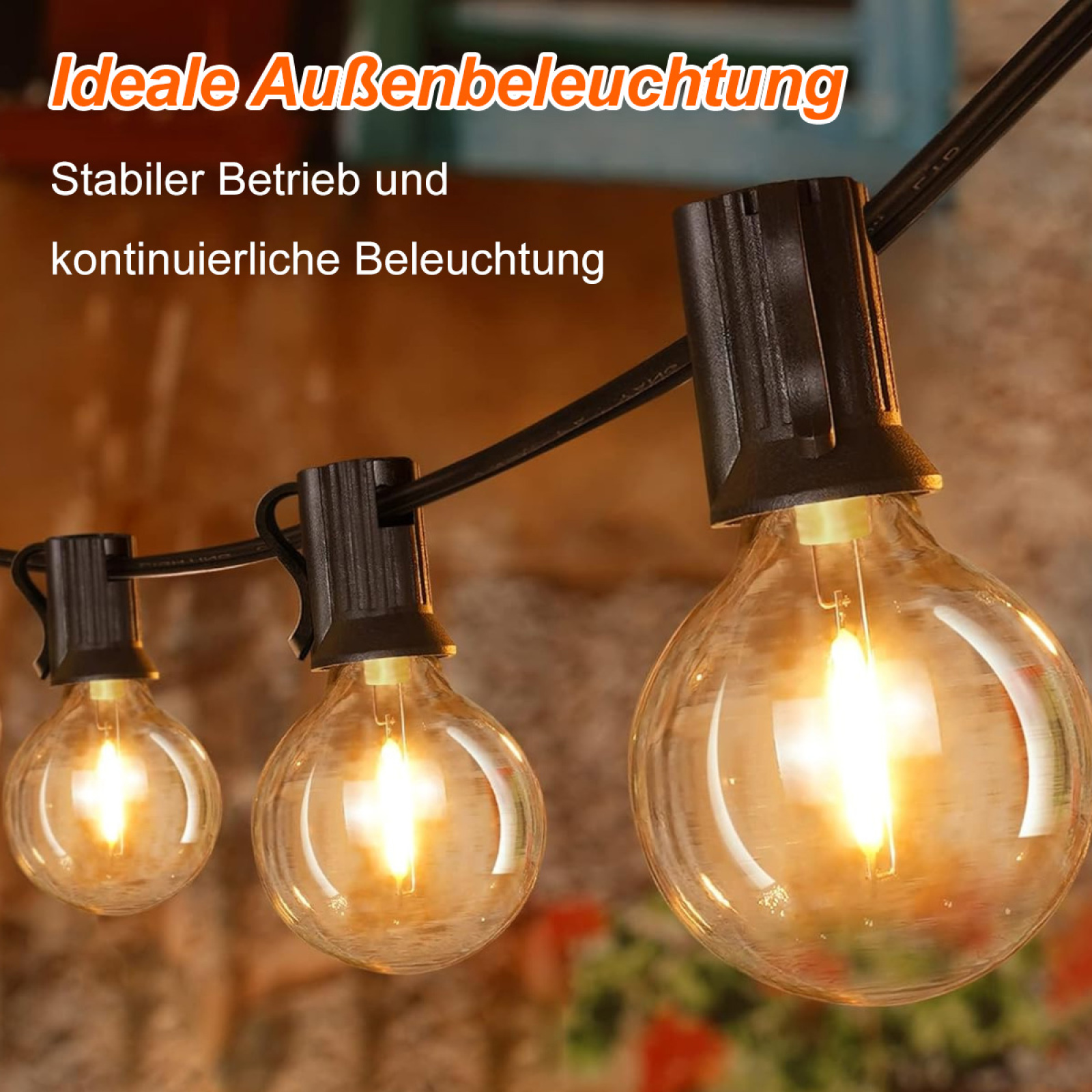 Nahaufnahme einer Lichterkette. Zeigt drei beleuchtete Glühbirnen vor einer Ziegelmauer.