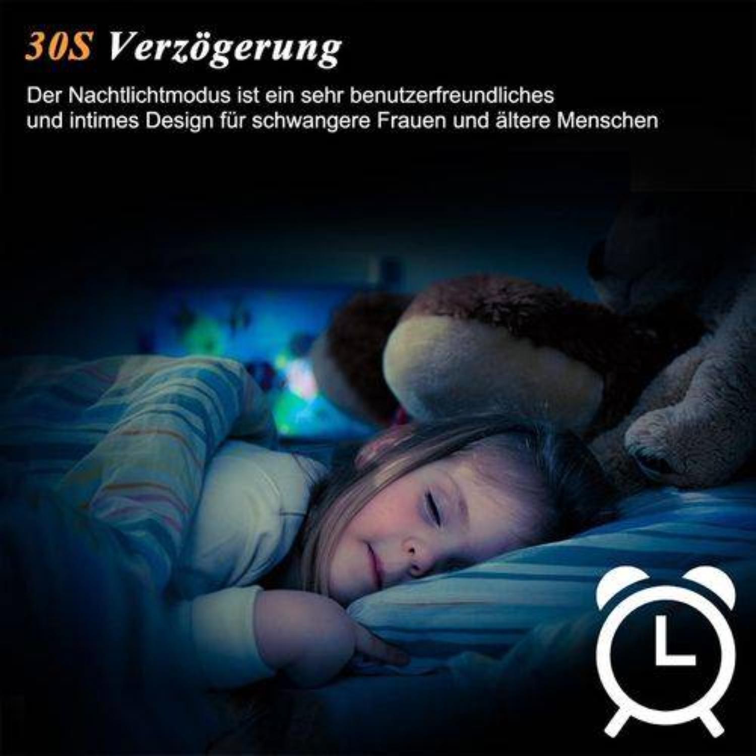 Ein Mädchen schläft im Bett mit einem Teddybär und einem Wecker in der Ecke.
