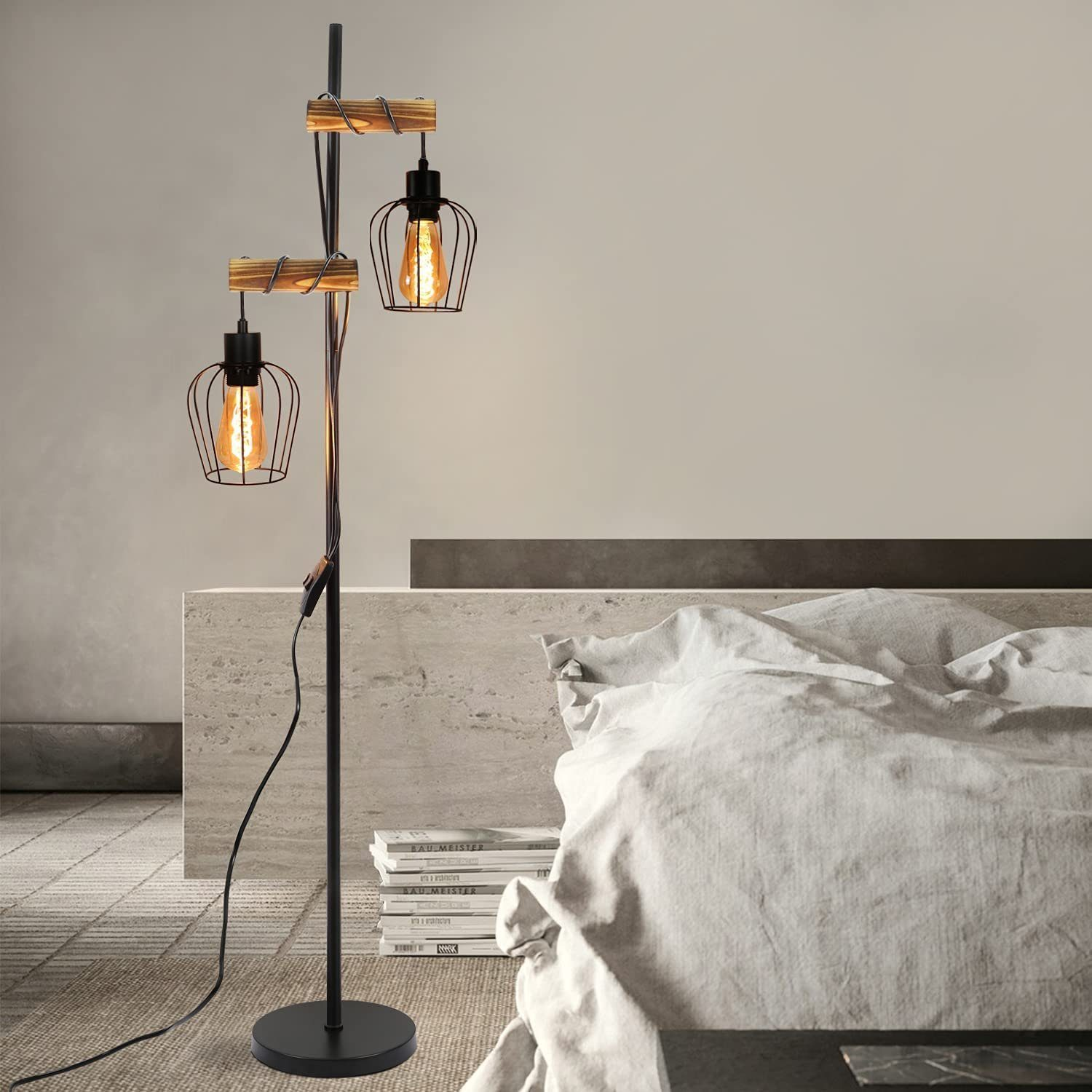 Lampada da terra con due luci. Le luci hanno un design a gabbia. Travi in legno le sostengono. Un letto sullo sfondo.