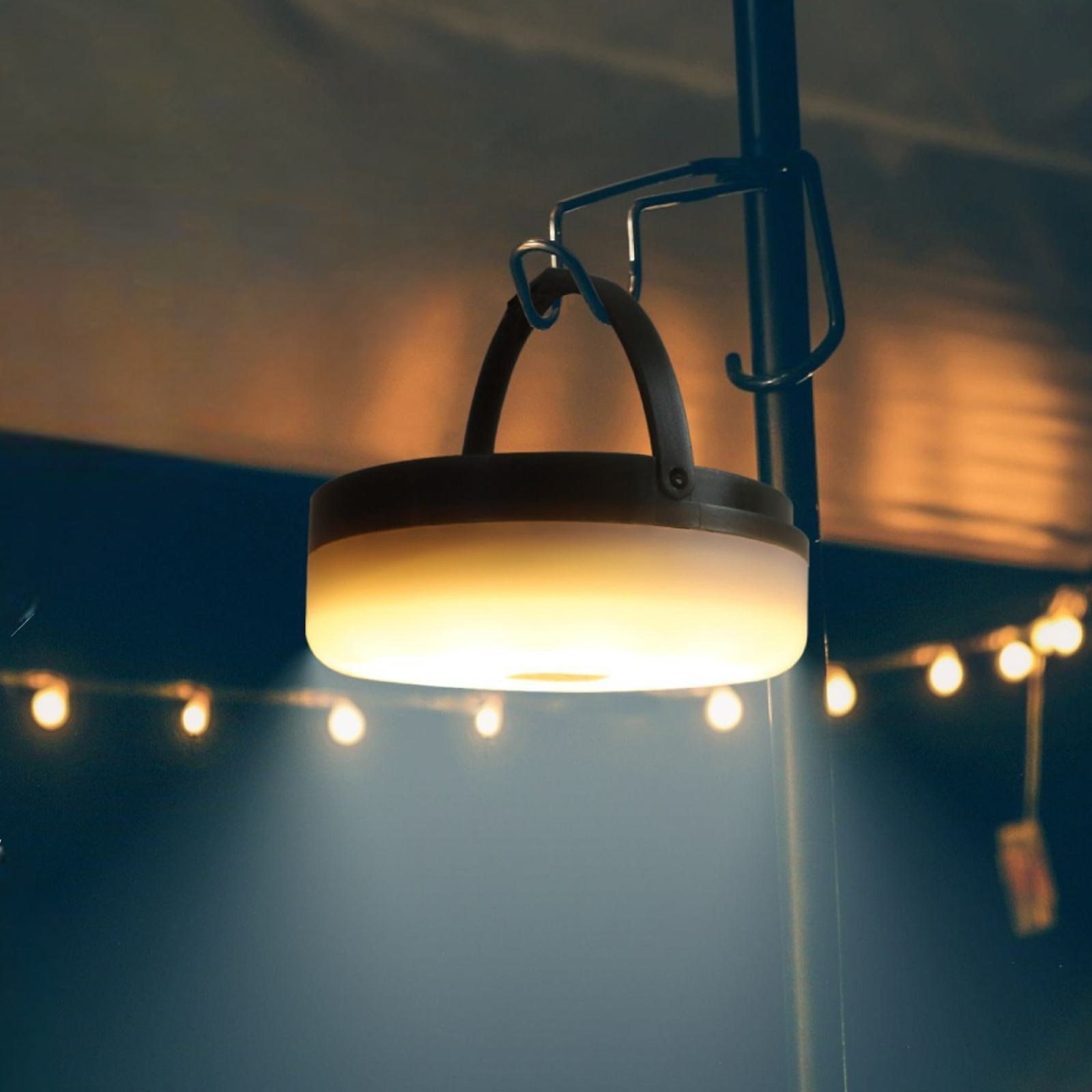 Laterne, die nachts hängt. Warmes Licht im Freien, mit dekorativen Lichtern.