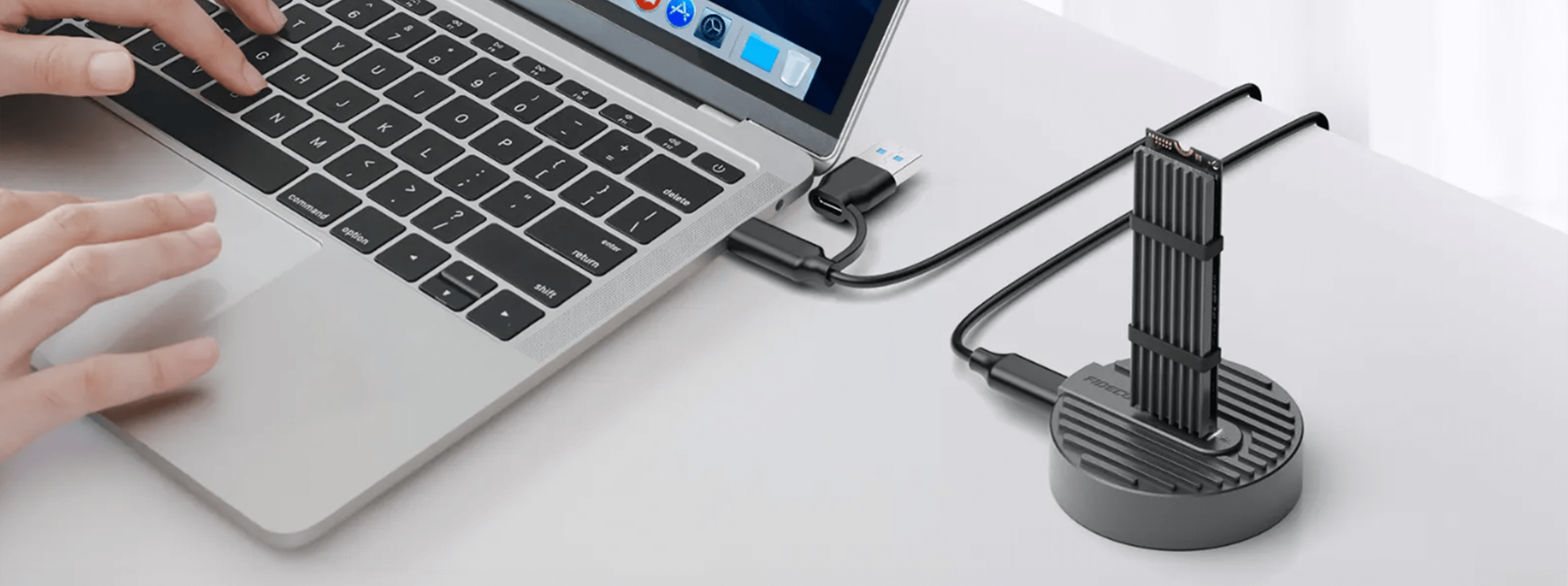 Laptop podłączony do urządzenia. Ręce na laptopie. Białe tło.