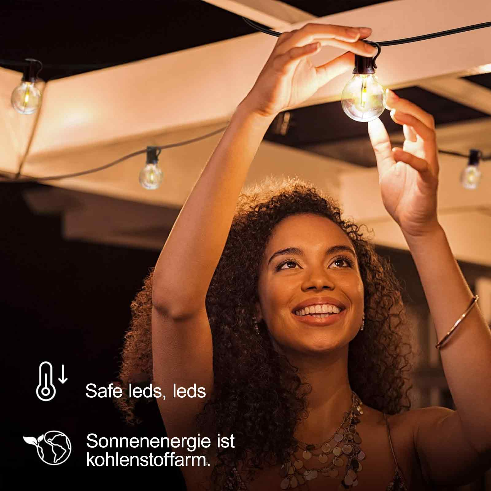 Eine Frau hält eine Glühbirne, mit weiteren Birnen und dem Text 'Sichere LEDs, Sonnenenergie ist kohlenstoffarm'.