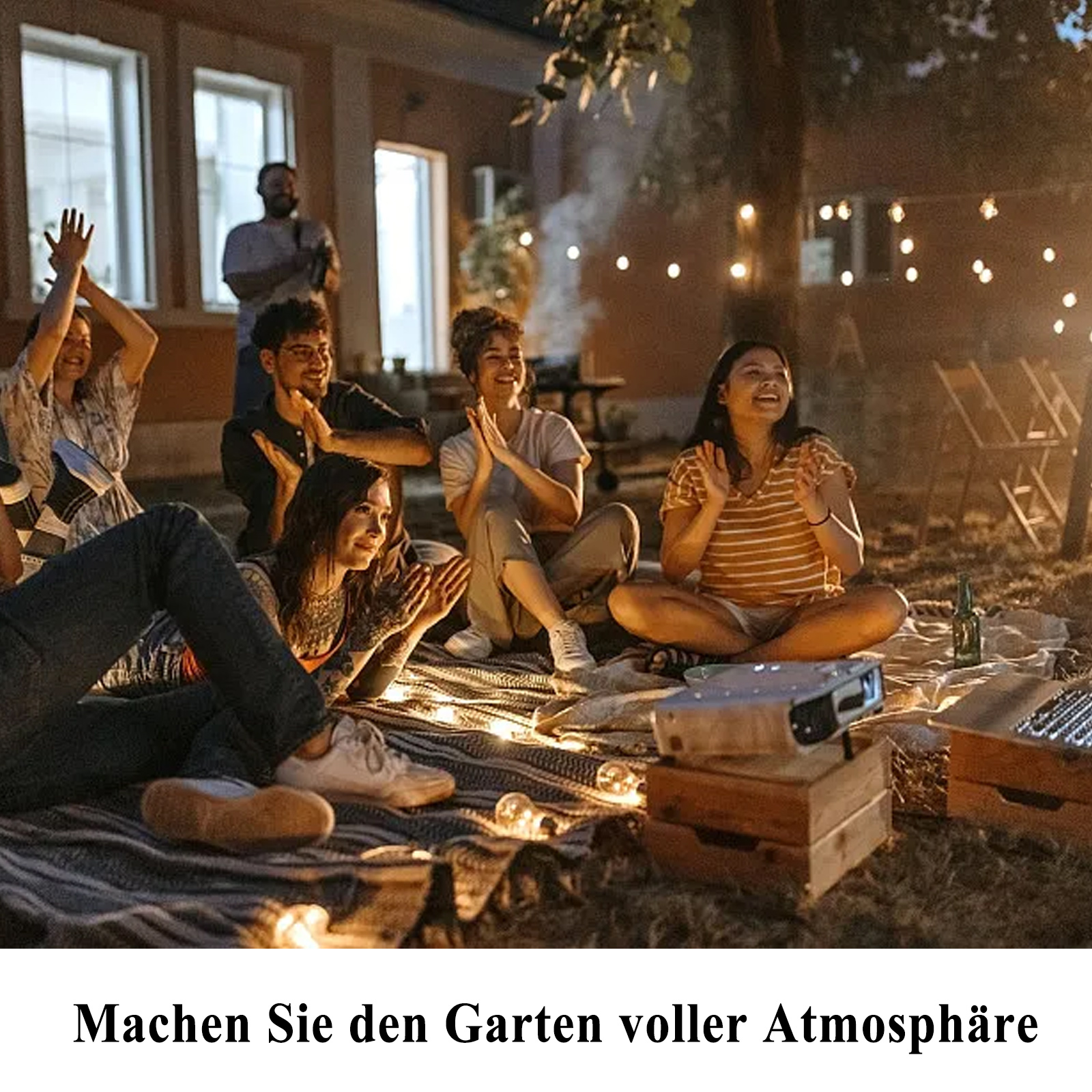 Eine Gruppe von Leuten, die klatschen, mit Lichterketten und einem Projektor im Hintergrund.