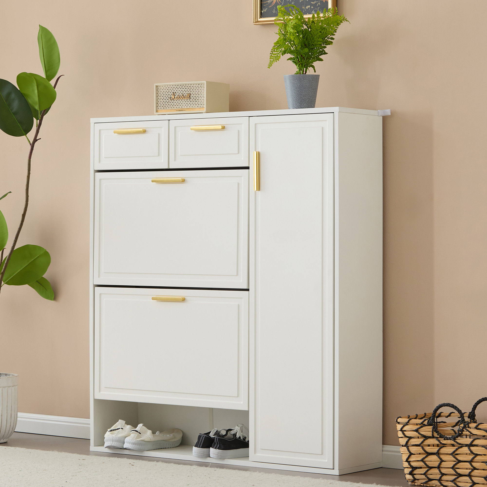 Weißer Schuhschrank mit goldenen Griffen, Schuhe innen, Pflanze oben, beige Wand.
