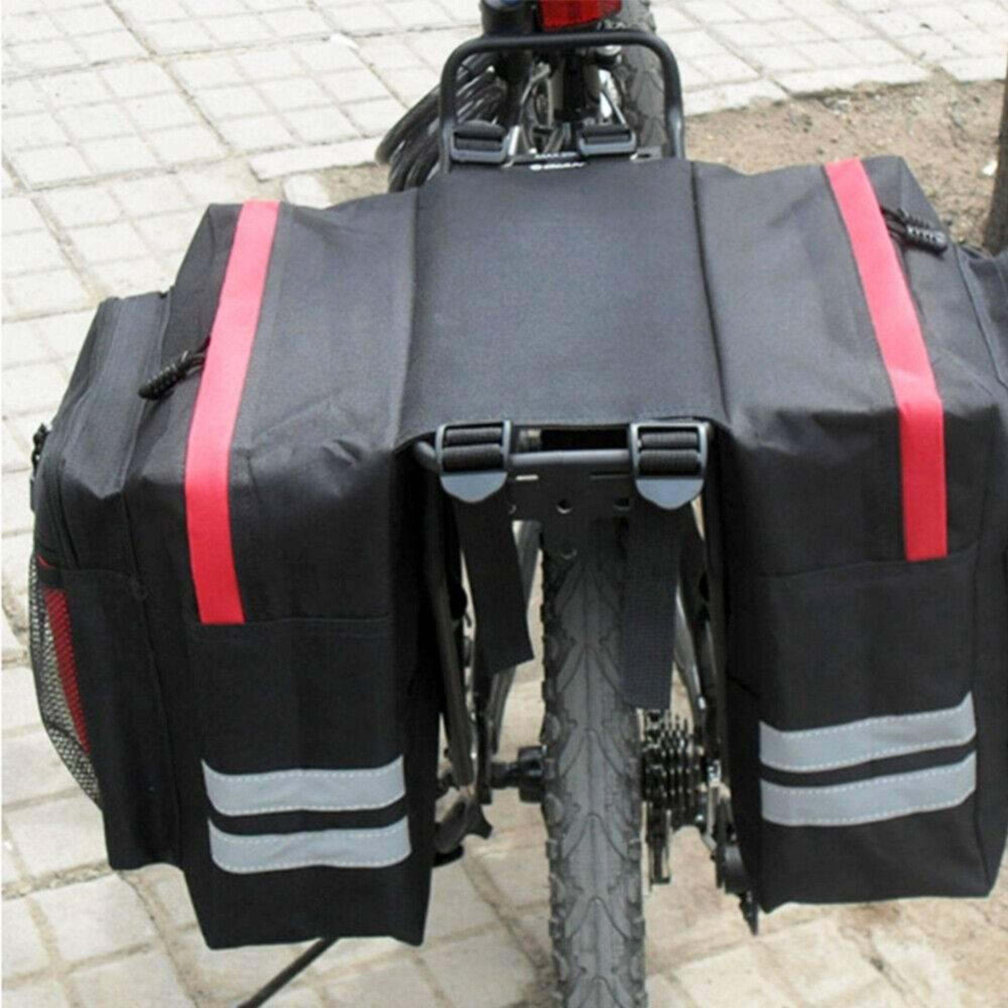 Schwarze Fahrradpacktaschen an einem Fahrrad. Rote Akzente und reflektierende Streifen. Umgebung im Freien.