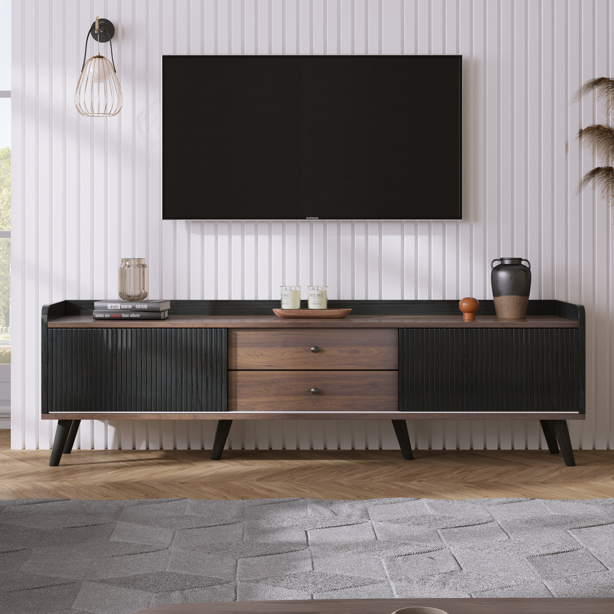 TV-Ständer mit schwarzem Fernseher, braunem Holz, schwarzen Akzenten und Dekoration. Ein Teppich.