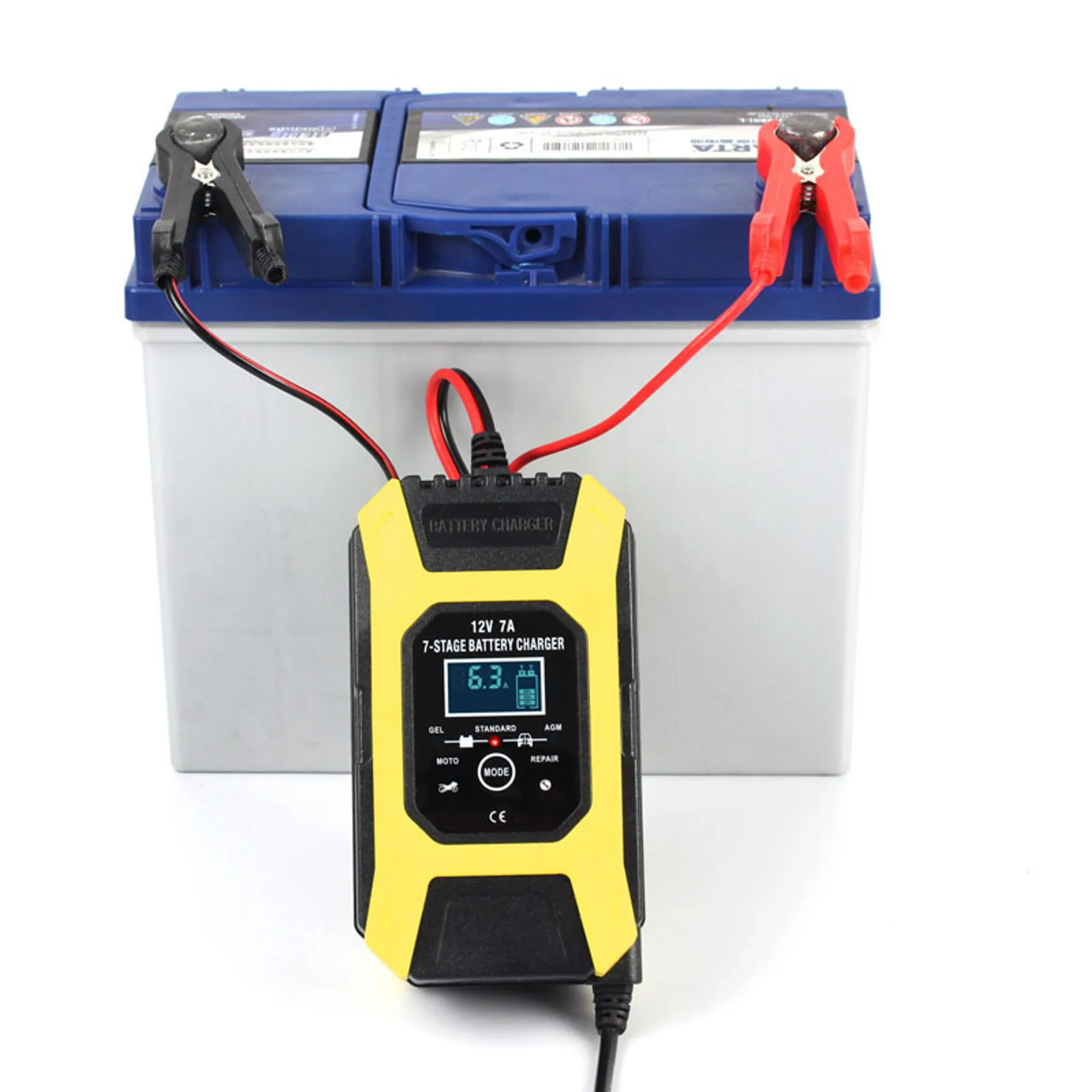 Ein gelbes Batterieladegerät, das an eine Autobatterie angeschlossen ist. Das Ladegerät hat eine Digitalanzeige.