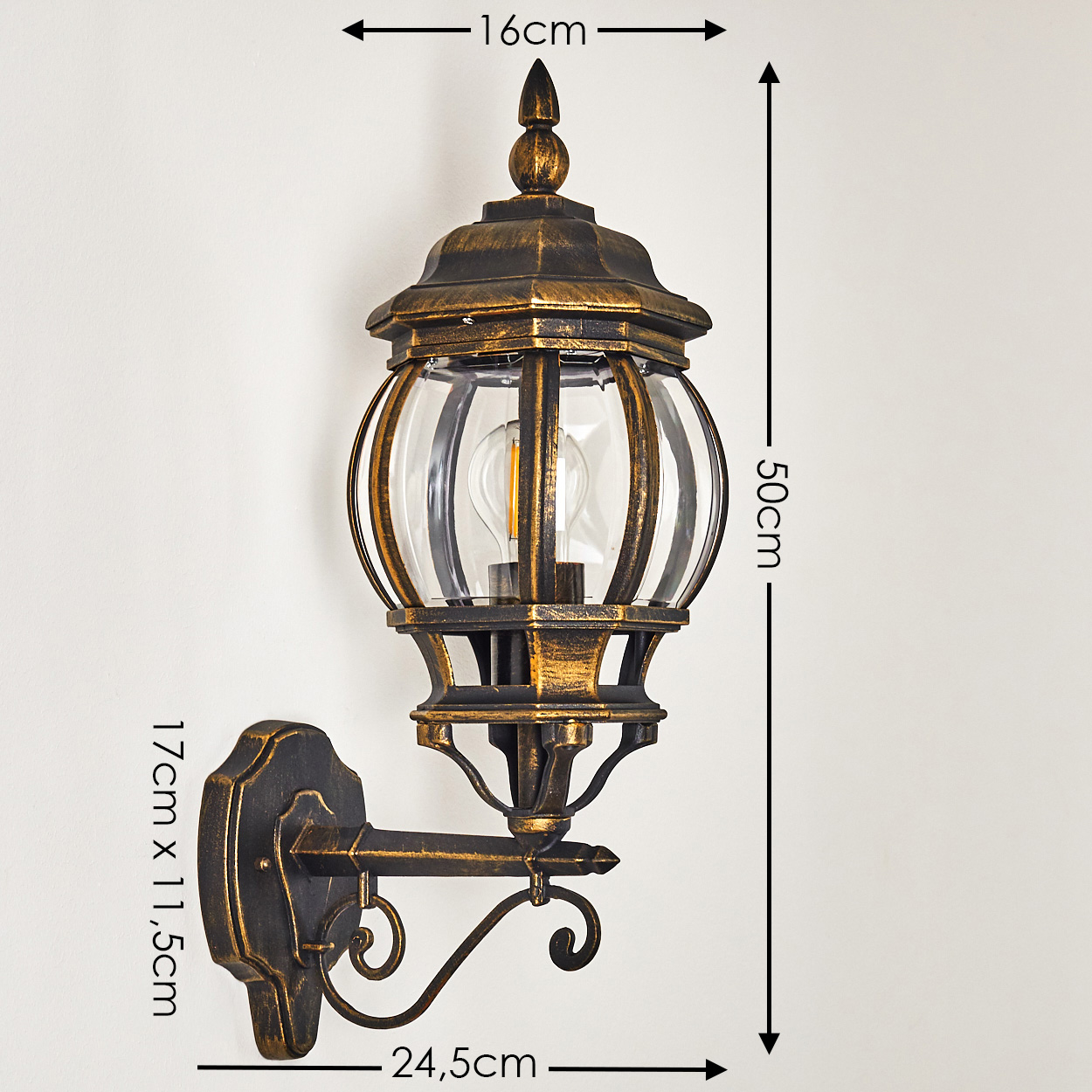 Verzierte Außenwandlampe, schwarz und gold. Abmessungen: 16 cm, 50 cm, 17 x 11,5 cm, 24,5 cm. Klare Glühbirne.