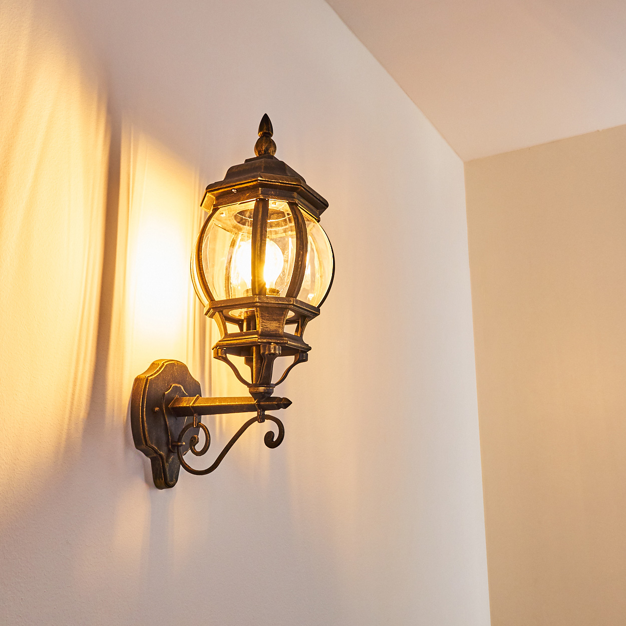 Außenwandleuchte wirft Licht und Schatten auf die Wand.