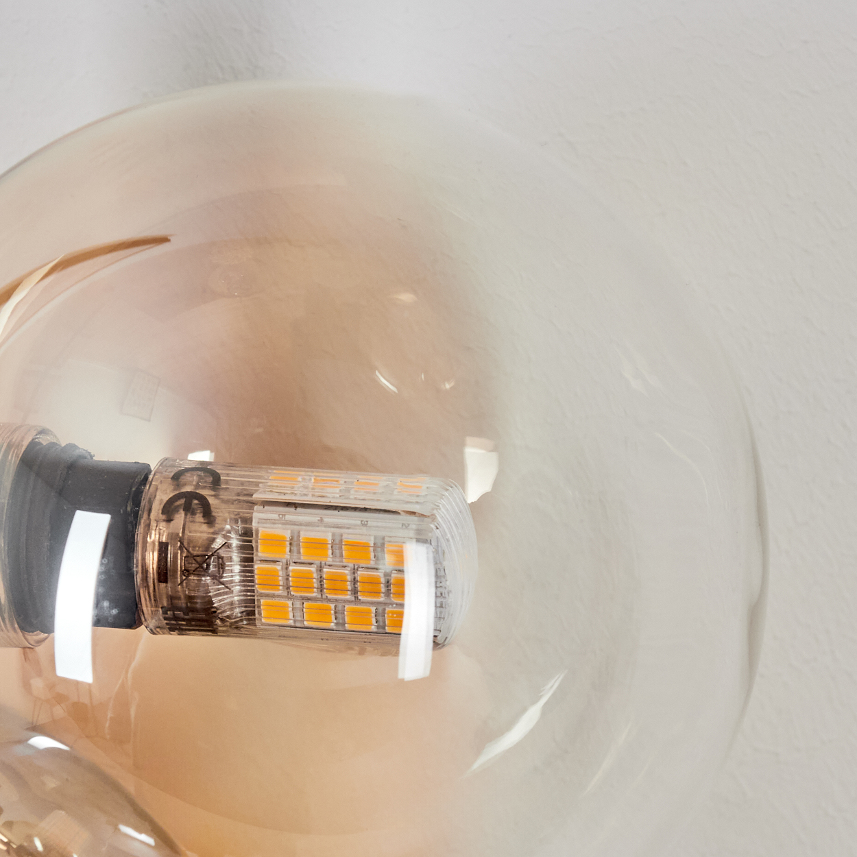 Nahaufnahme einer Glühbirne in einem transparenten Glaskugelförmigen Gehäuse.