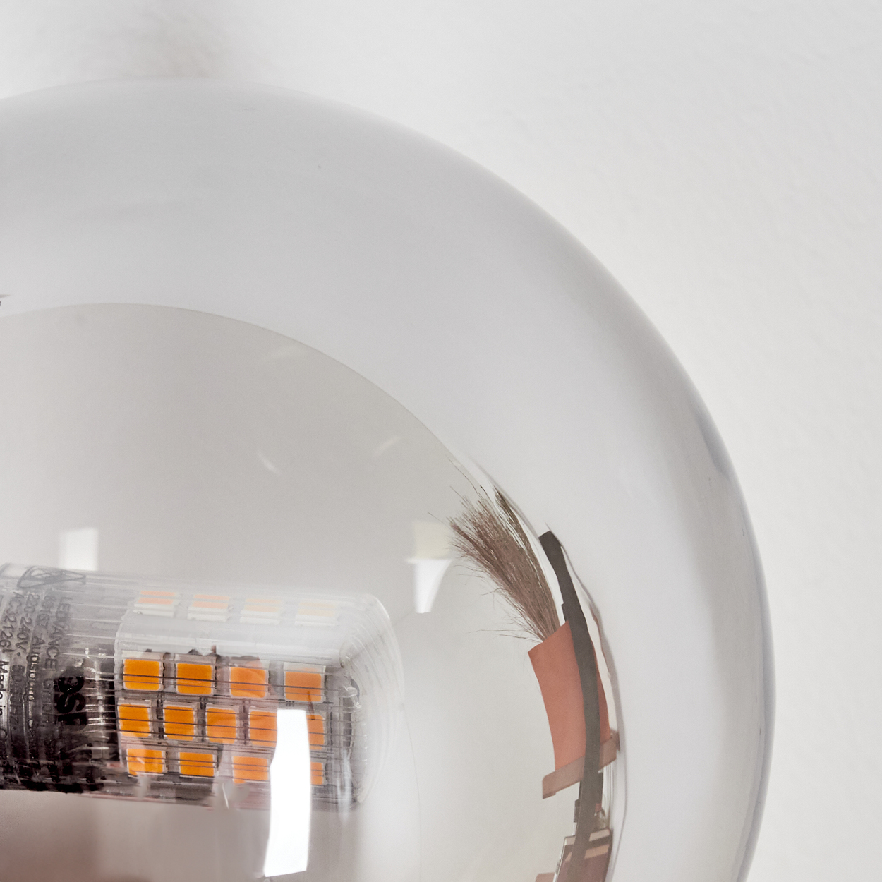 Nahaufnahme einer klaren Glaskugel mit einer LED-Leuchte. Das Glas reflektiert das Licht.