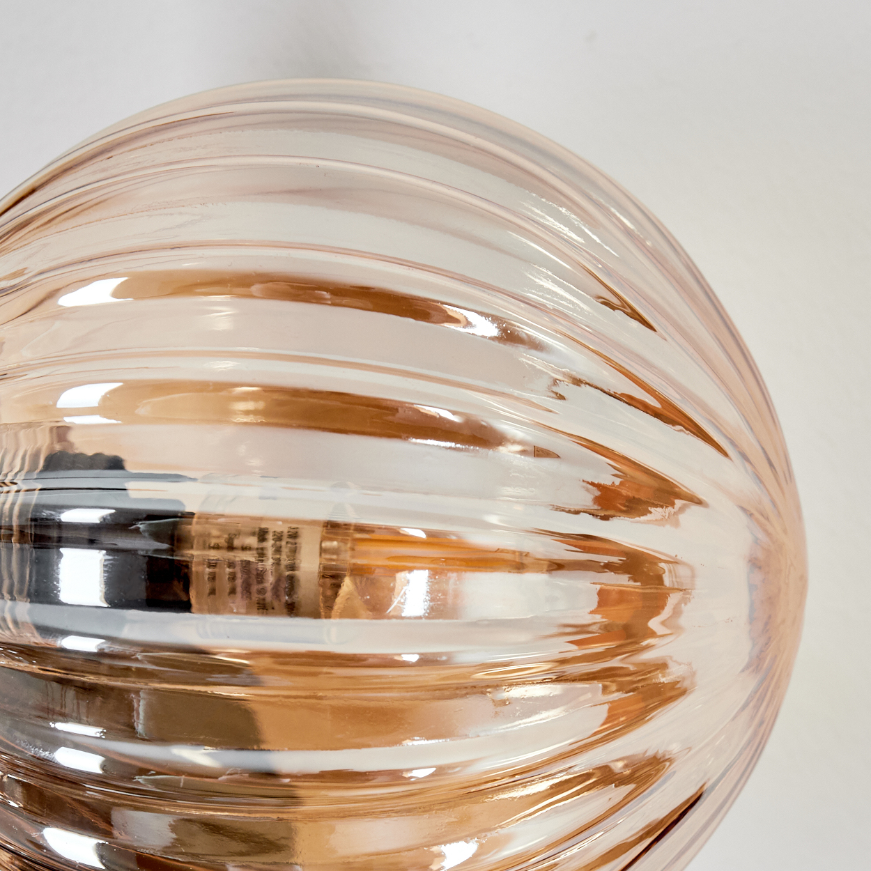 Nahaufnahme einer strukturierten Glaskugel mit reflektierender bernsteinfarbener Farbe.