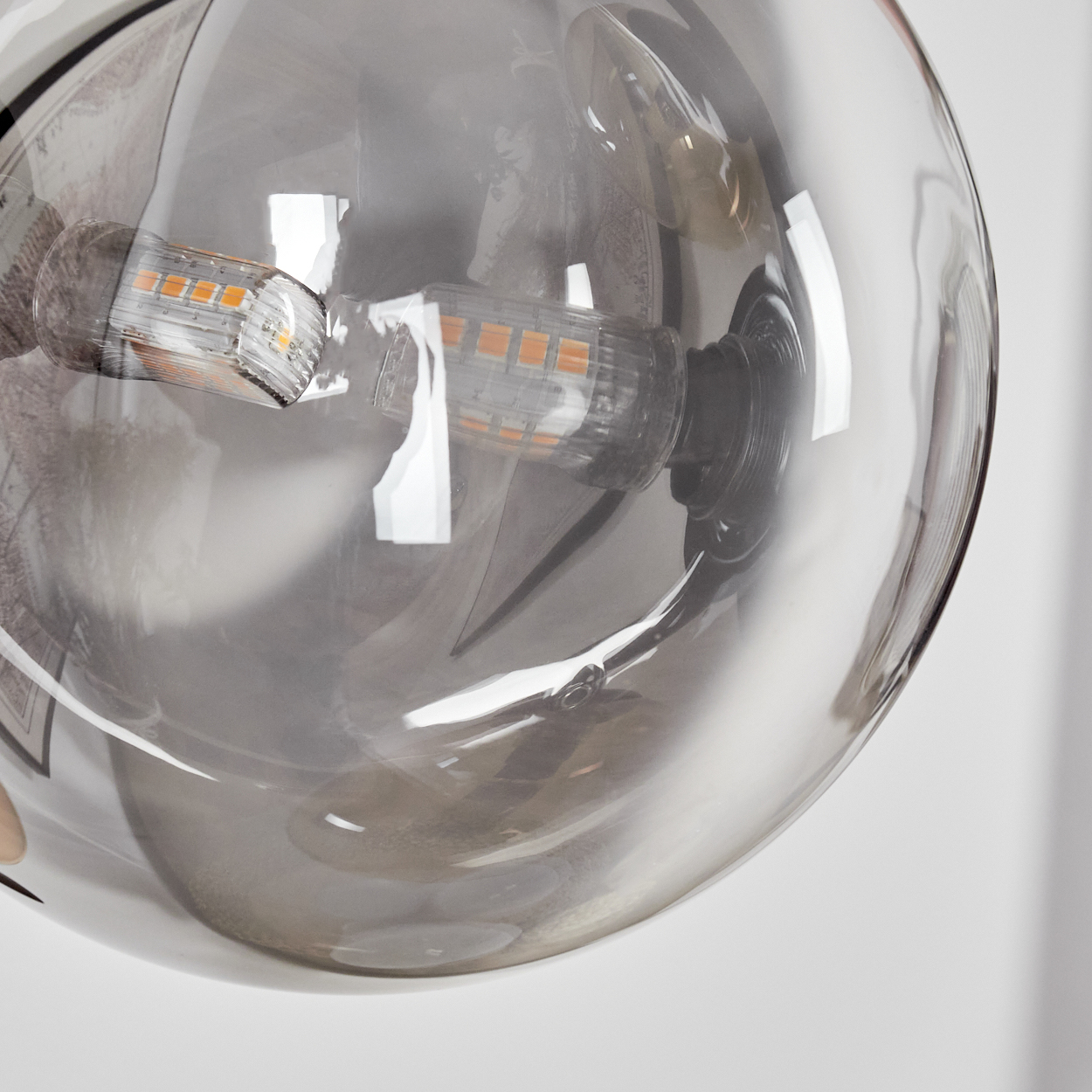 Nahaufnahme einer Glühbirne in einer transparenten grauen Glaskugel.