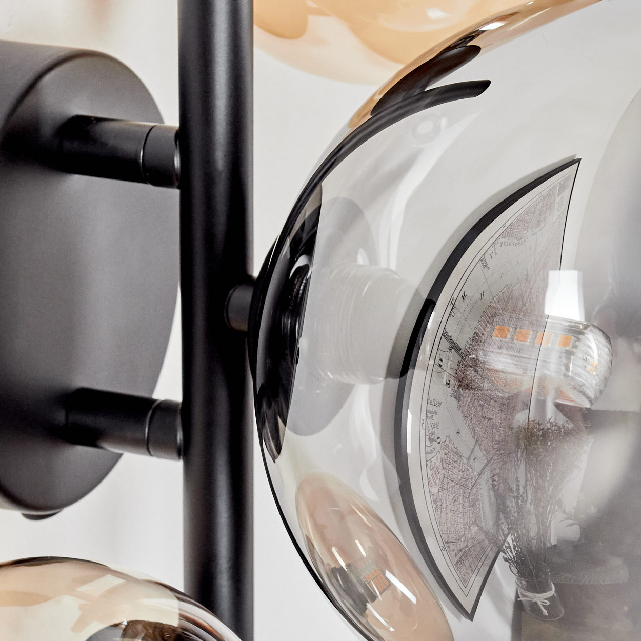 Nahaufnahme einer schwarzen Lampe mit transparenten und bernsteinfarbenen Glühbirnen.