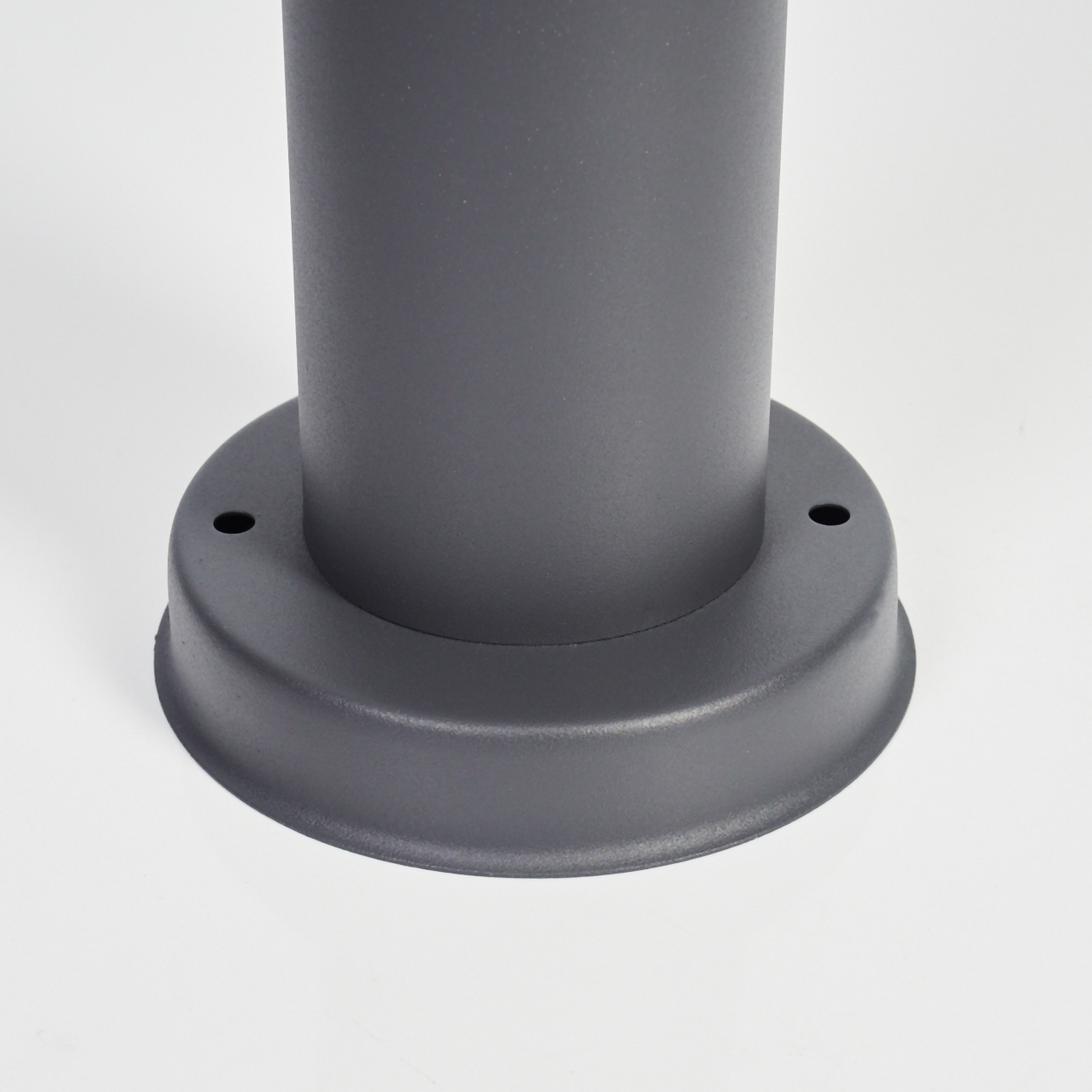 Grauer zylindrischer Sockel einer Lampe mit kreisförmiger Basis und zwei Löchern.