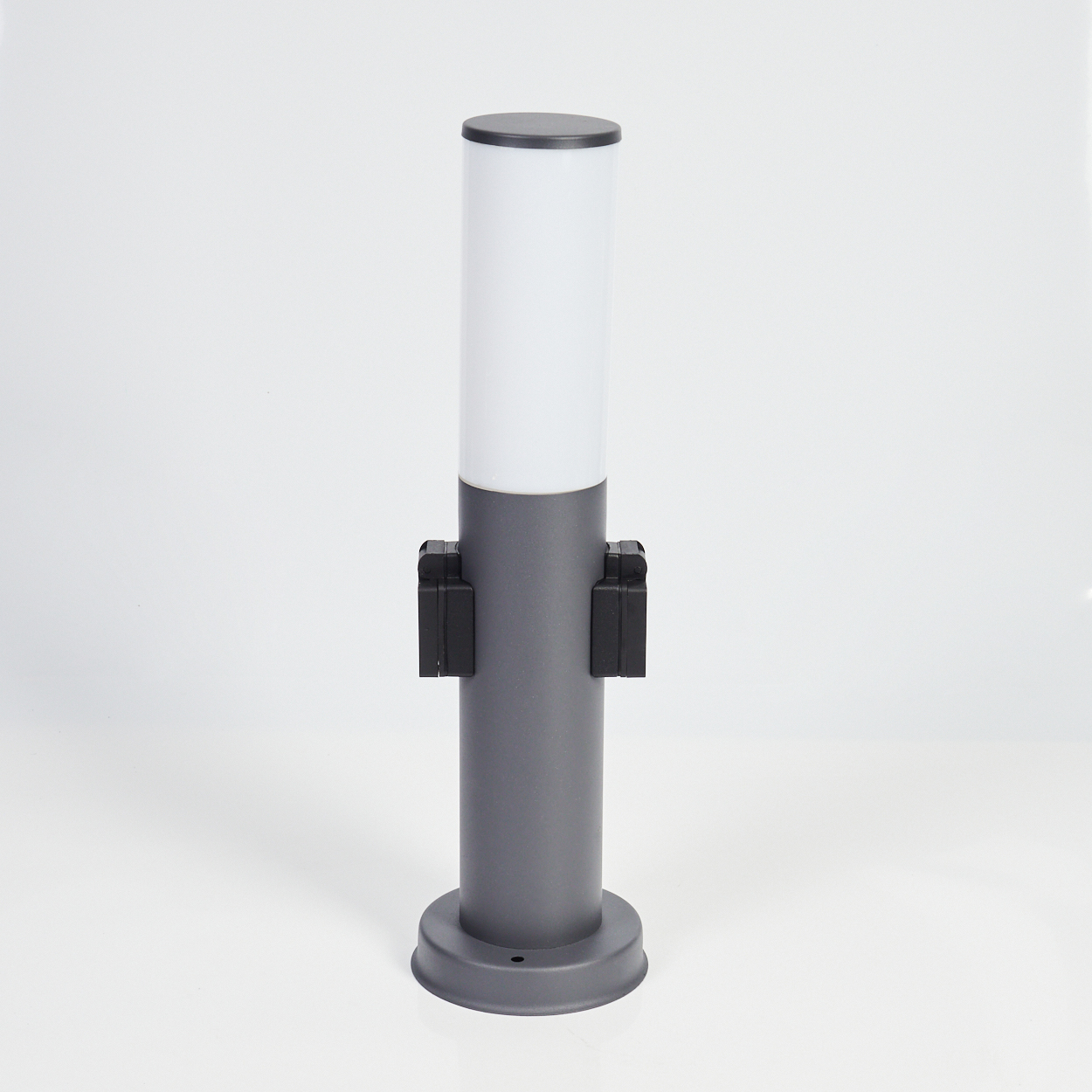 Graue Außenlampe mit weißem Zylinderaufsatz und zwei schwarzen Sensoren. Weißer Hintergrund.